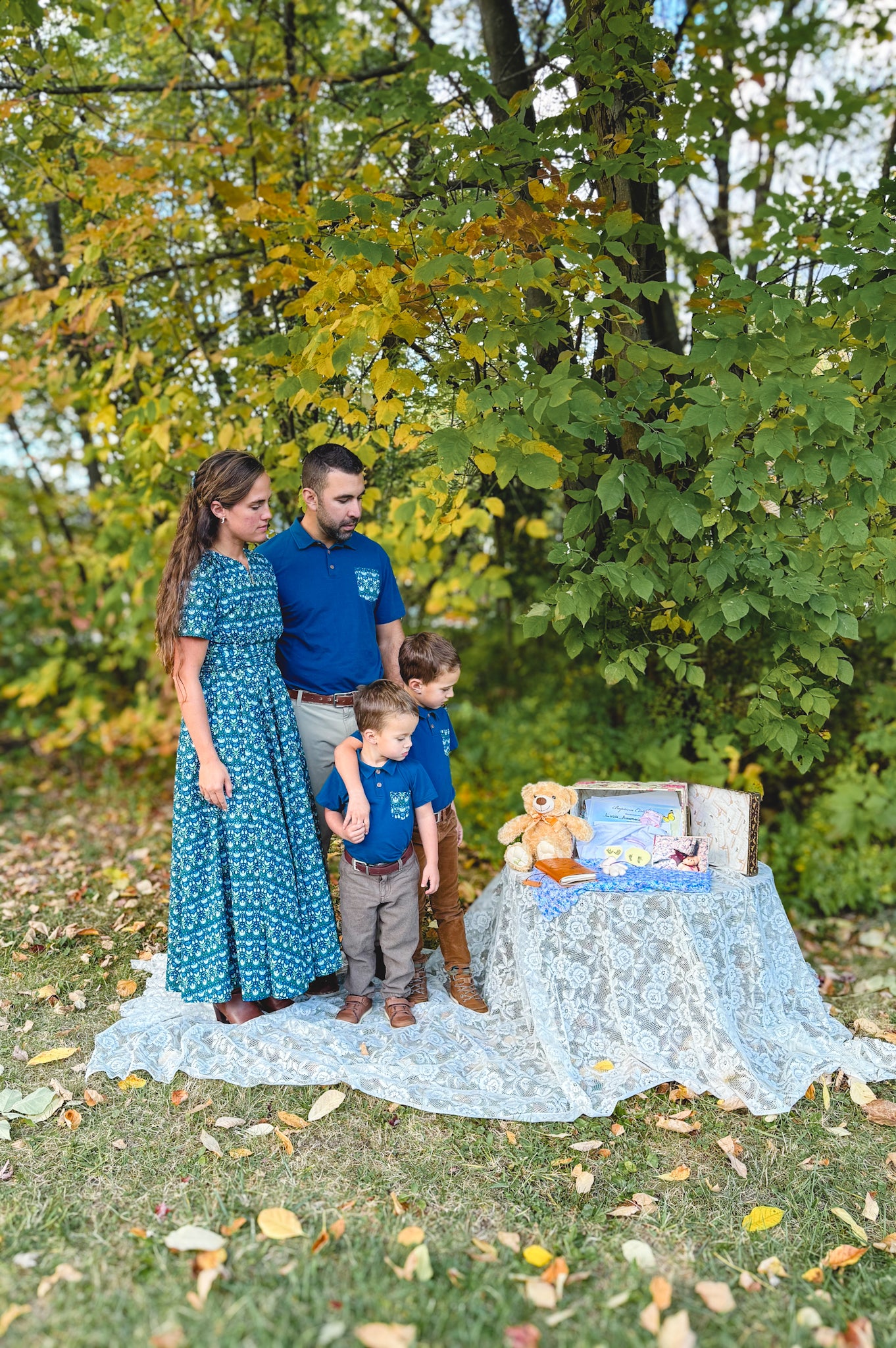 Family of four with baby blanket and teddy.