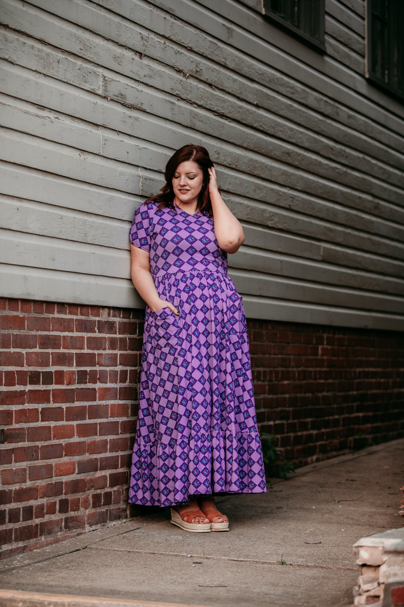 Woman in a purple checkered modest nursing dress.