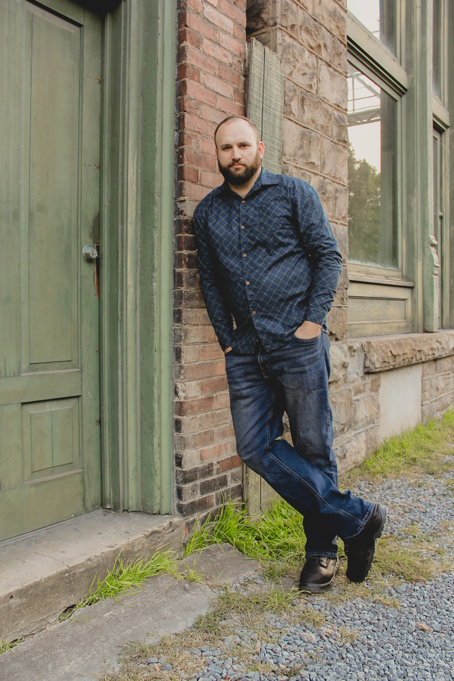 Man in plaid shirt by green door