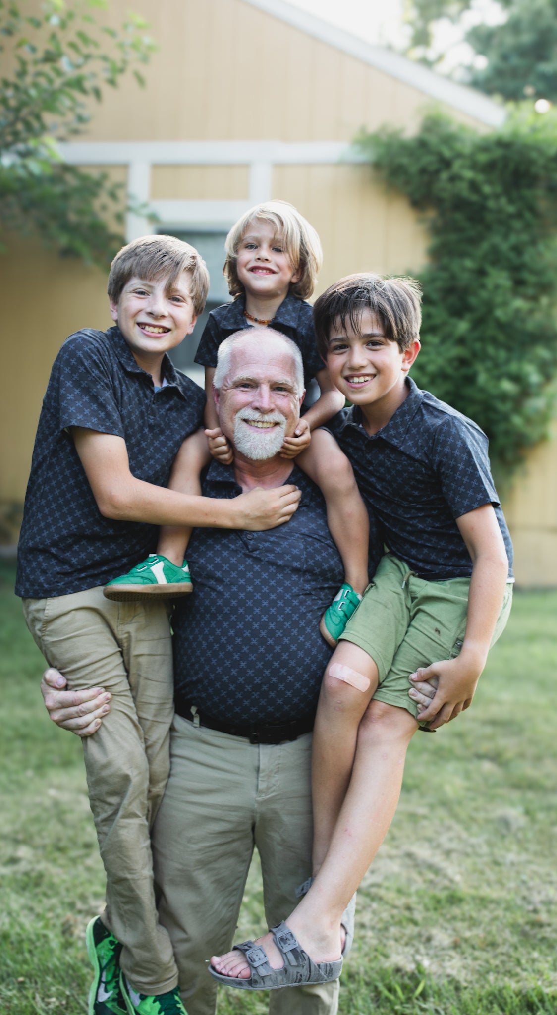 Young boys wearing dark blue polo shirts with their father in a matching shirt