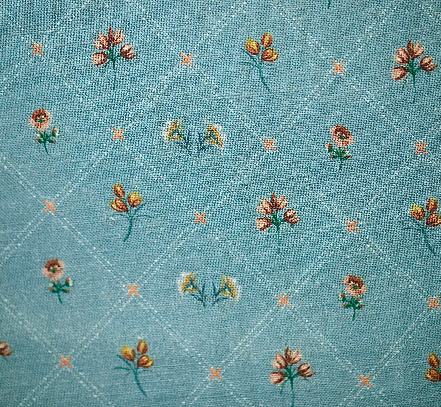 Embroidered floral pattern on a blue fabric background