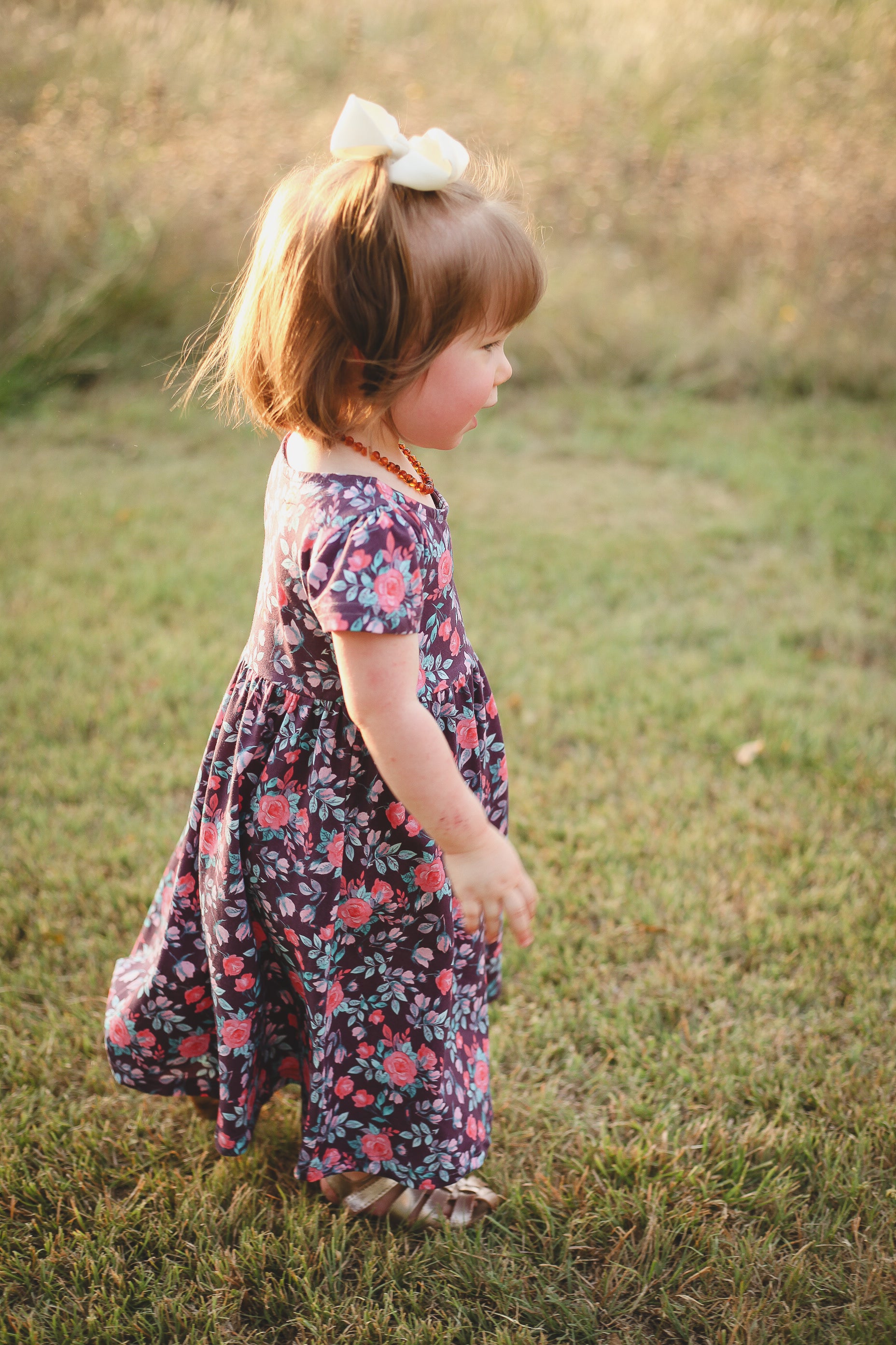 Young girl in floral dress on grass