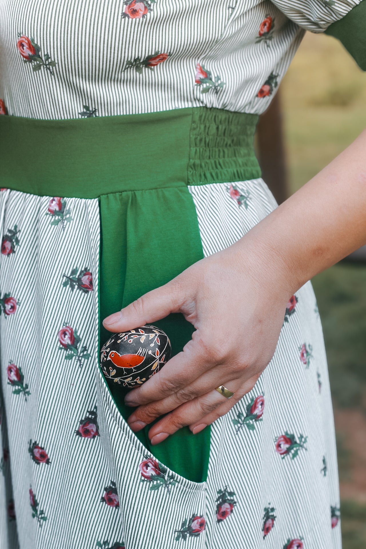 woman wearing a green and white striped modest nursing dress
