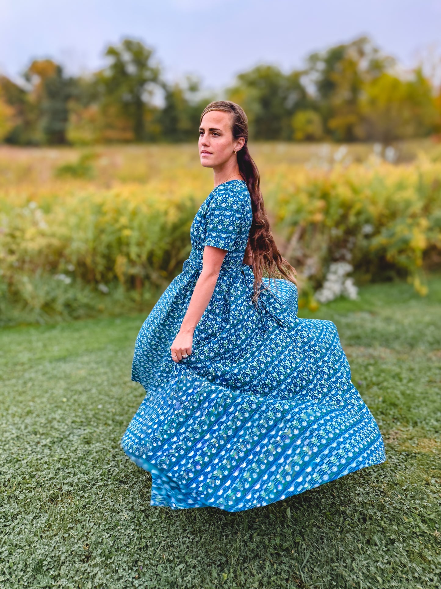 Woman in modest nursing dress in field
