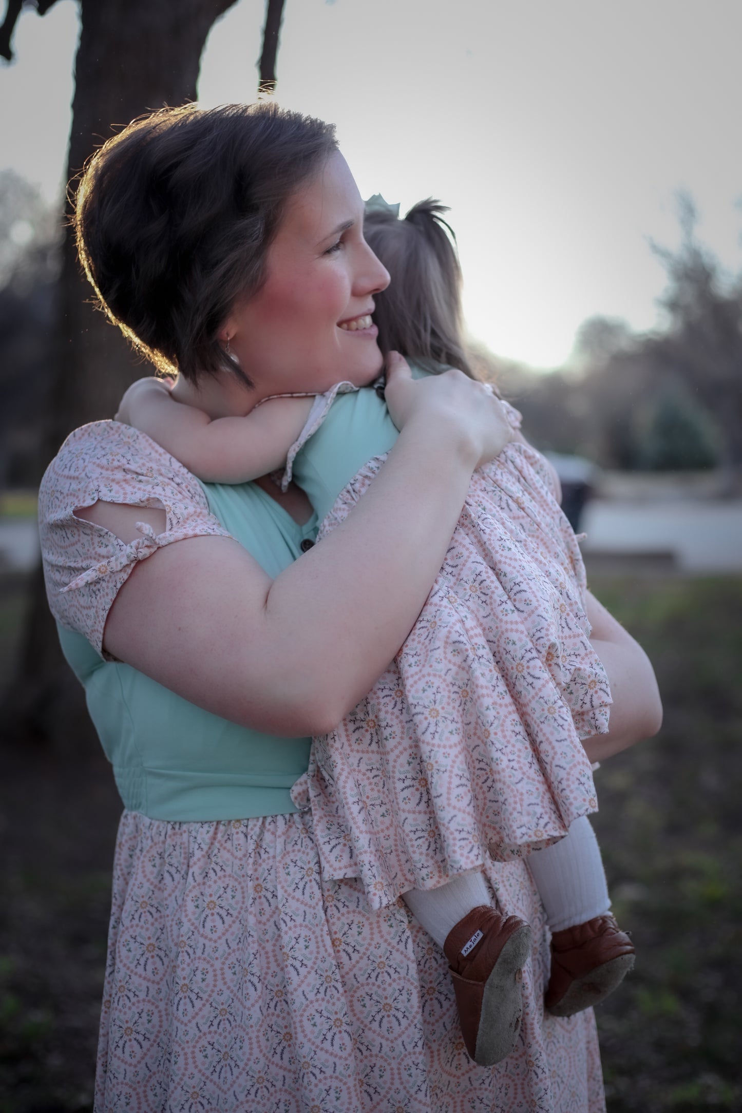 A woman wearing a vintage style modest nursing dress with her daughter in hand.