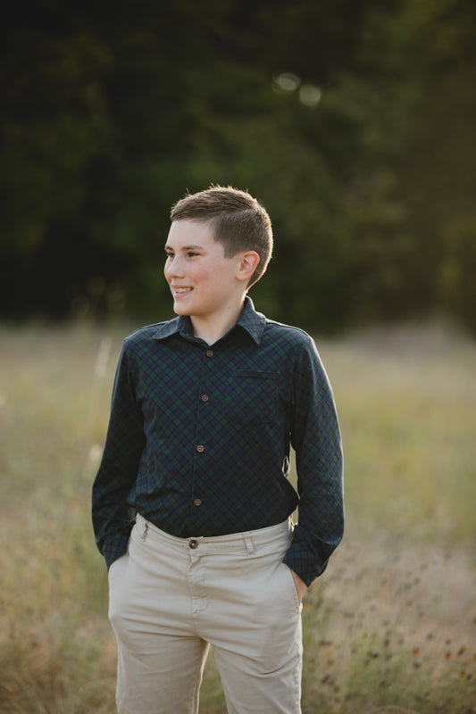 Boy in green plaid button-up shirt outdoors