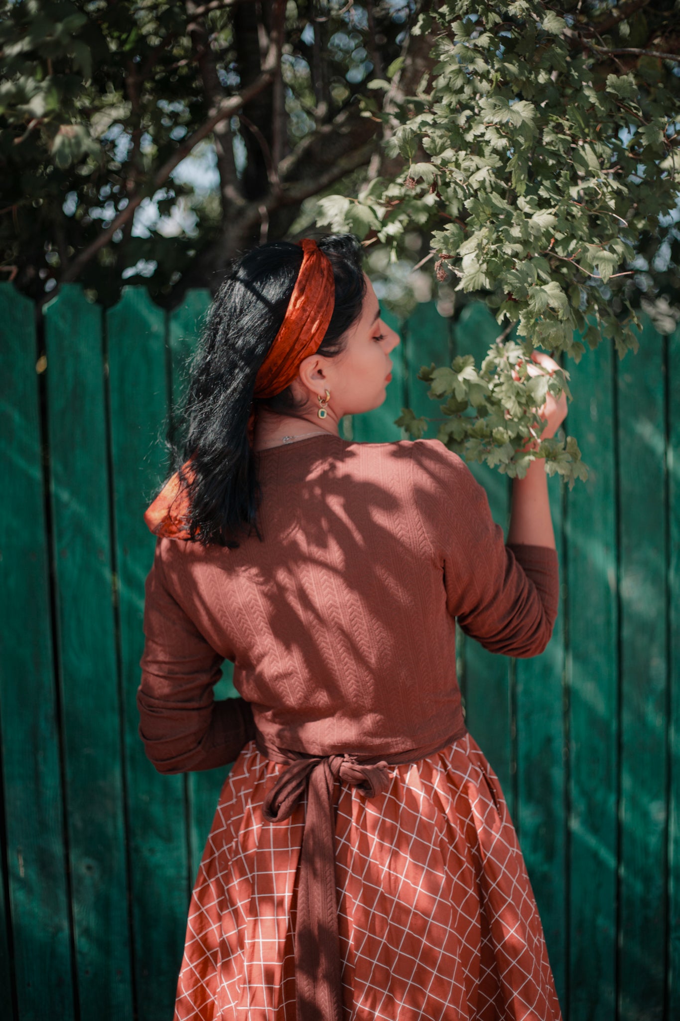 Woman in modest nursing brown dress fence branch