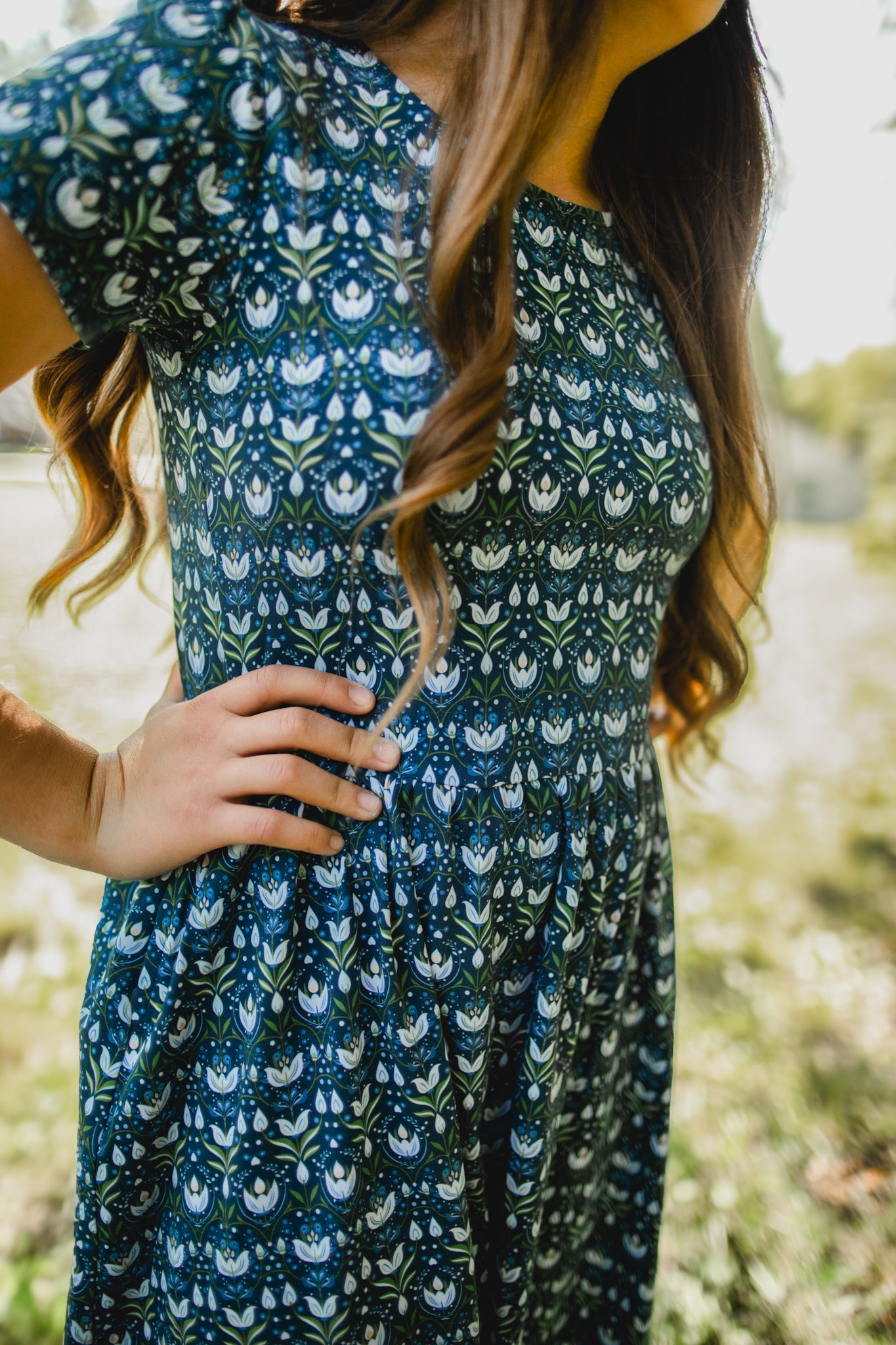 Woman in modest nursing dress with blurred natural background