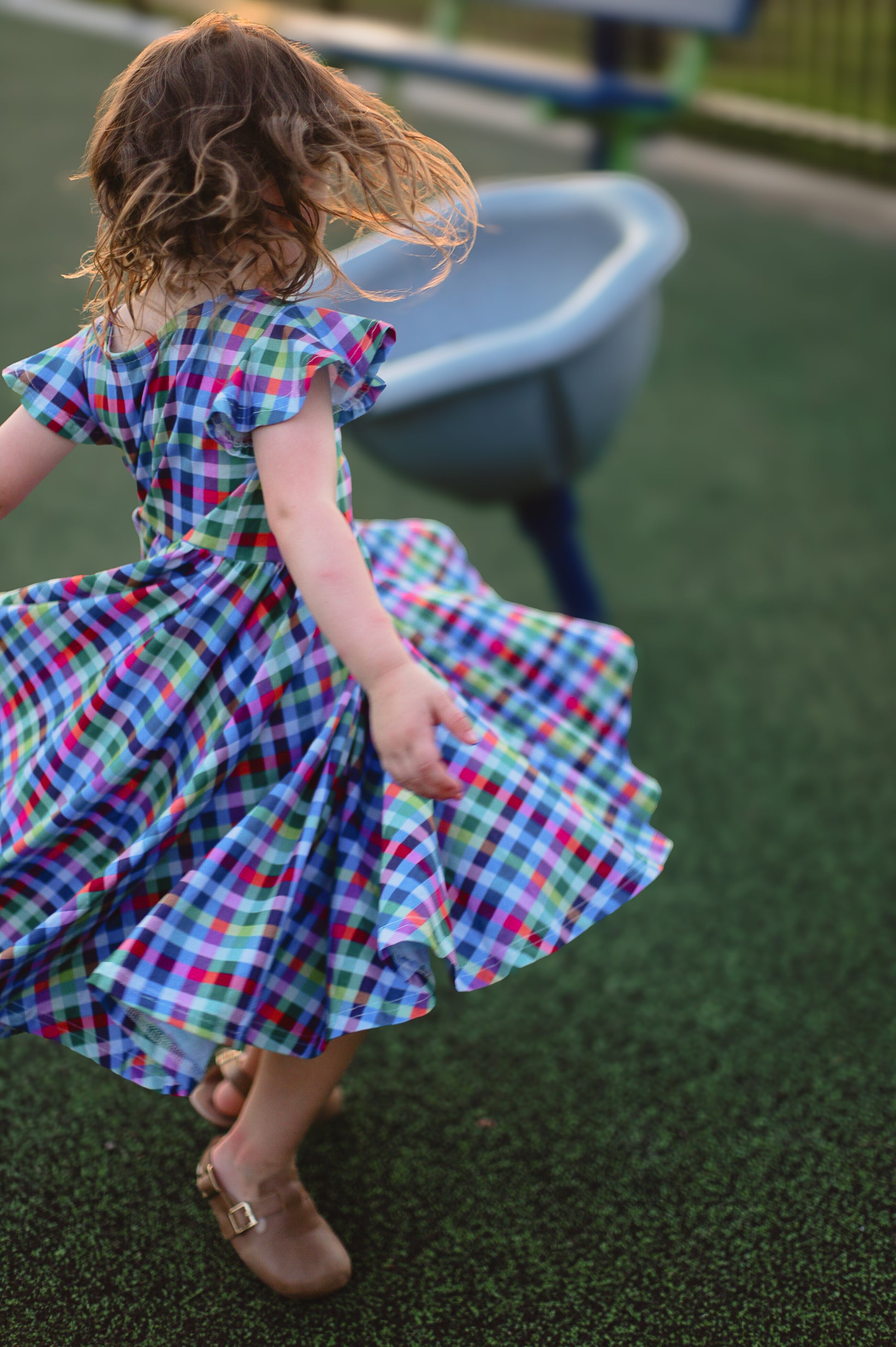 Young girl in a colorful checkered modest dress