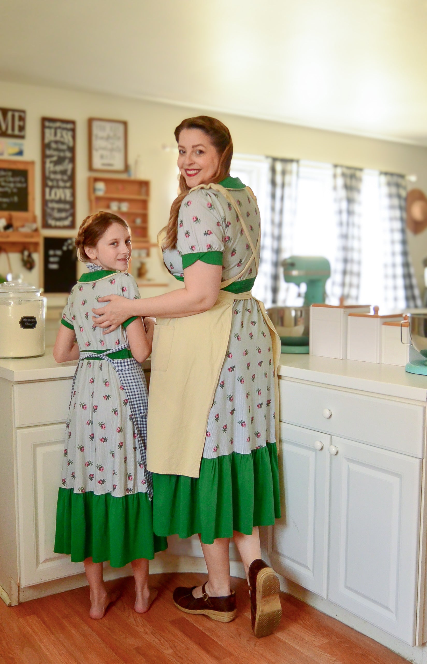 woman wearing a green and white striped modest nursing dress with her daughter wearing a matching dress