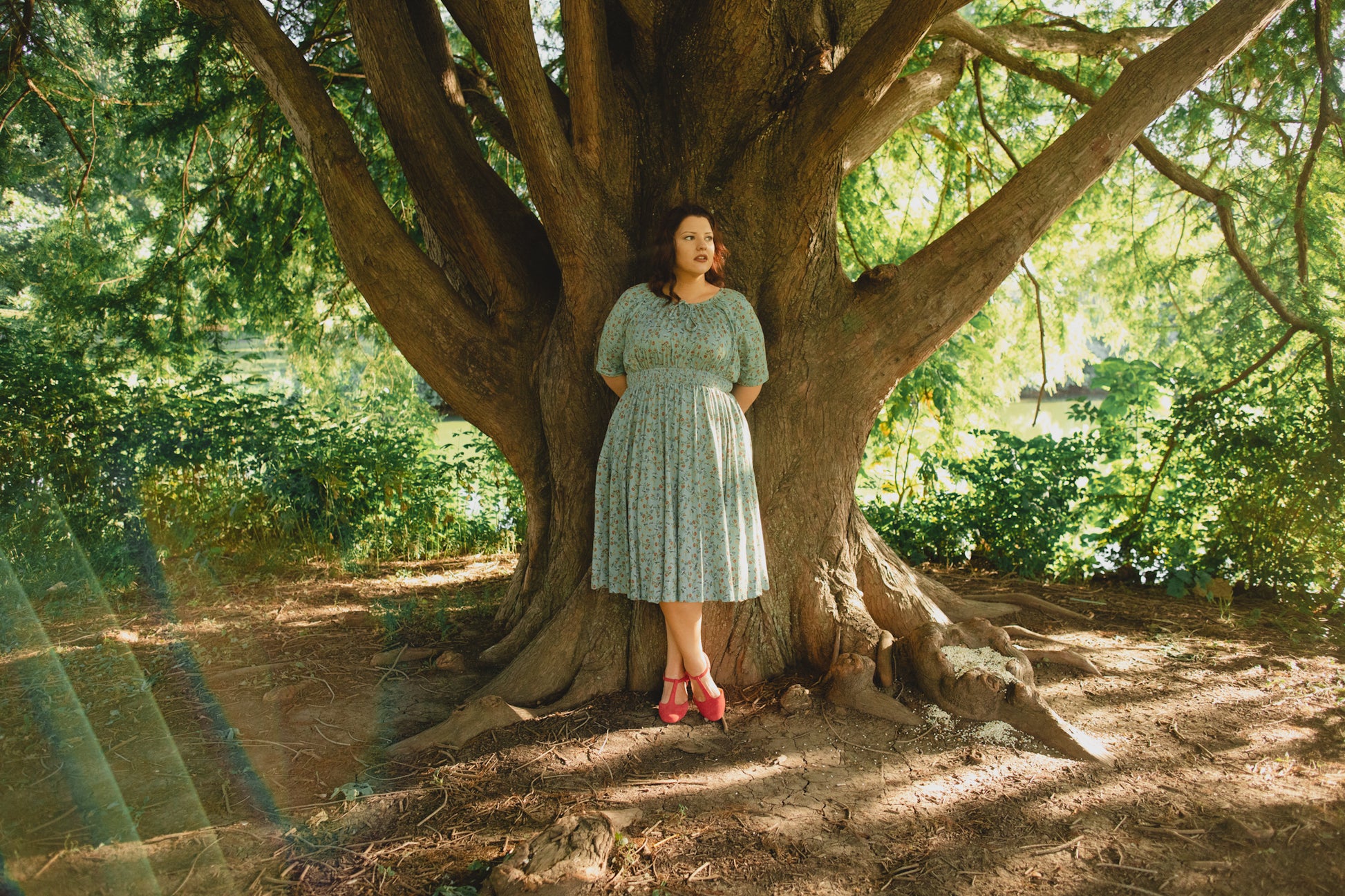 Woman in modest nursing dress under tree