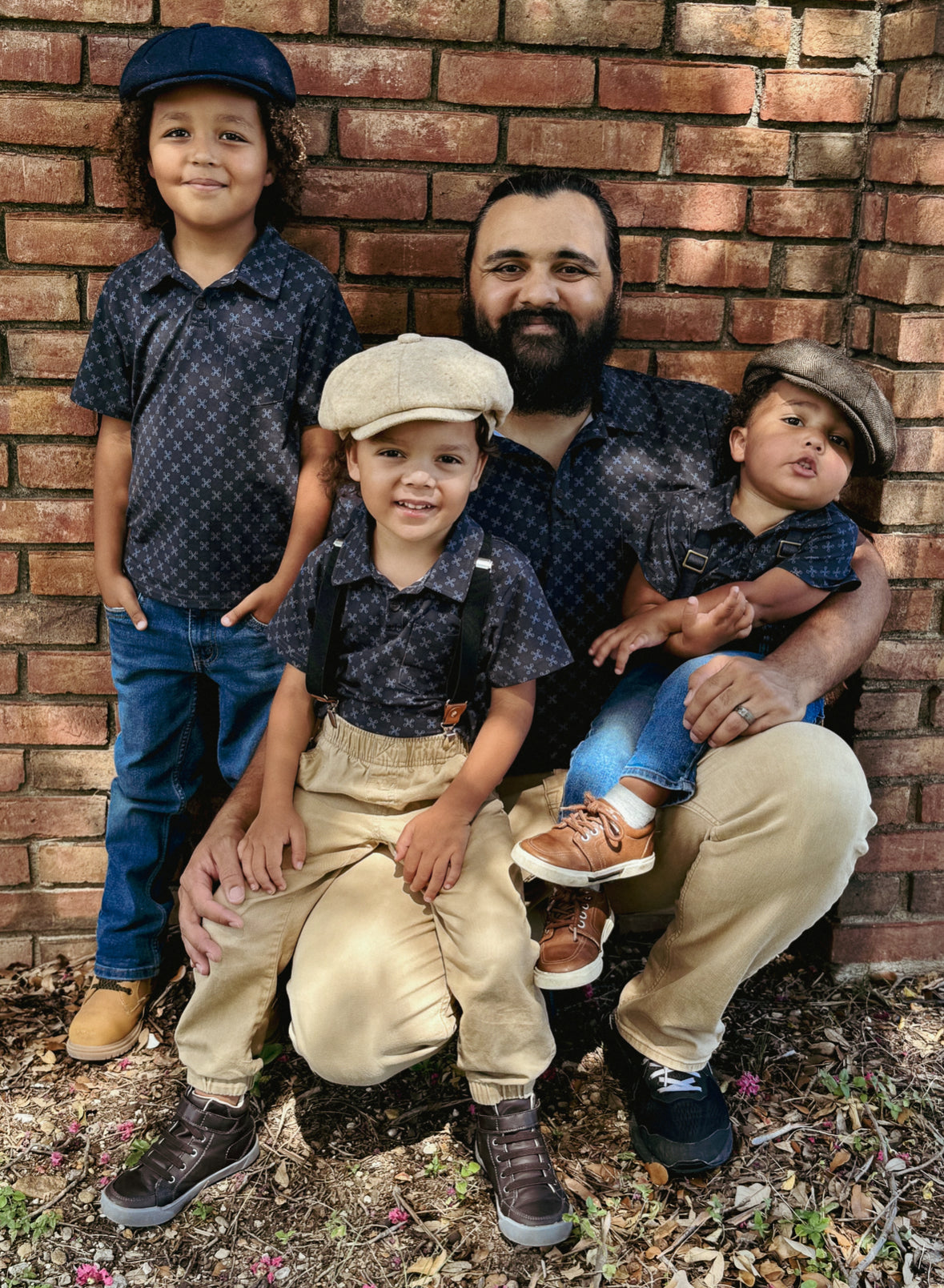 Young boys wearing dark blue polo shirts with their father in a matching shirt