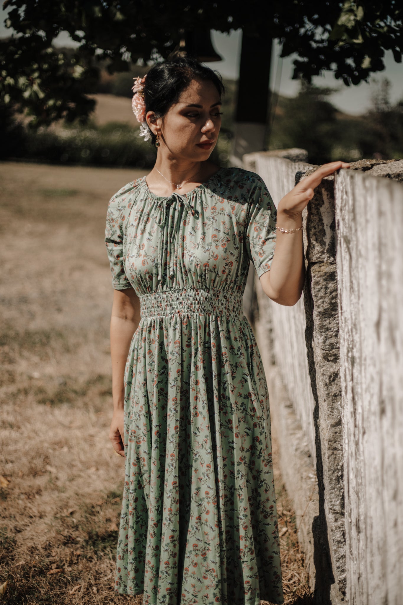 Woman in modest nursing dress by fence