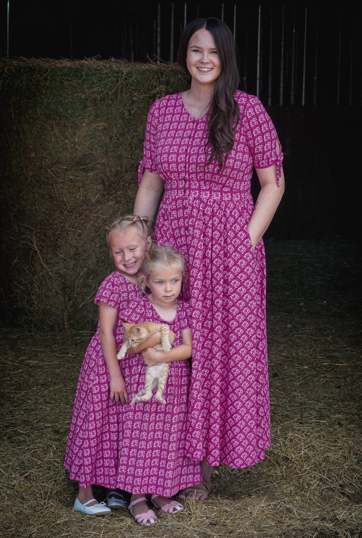 Young girls in modest pink dresses with their mother wearing a modest pink nursing dress