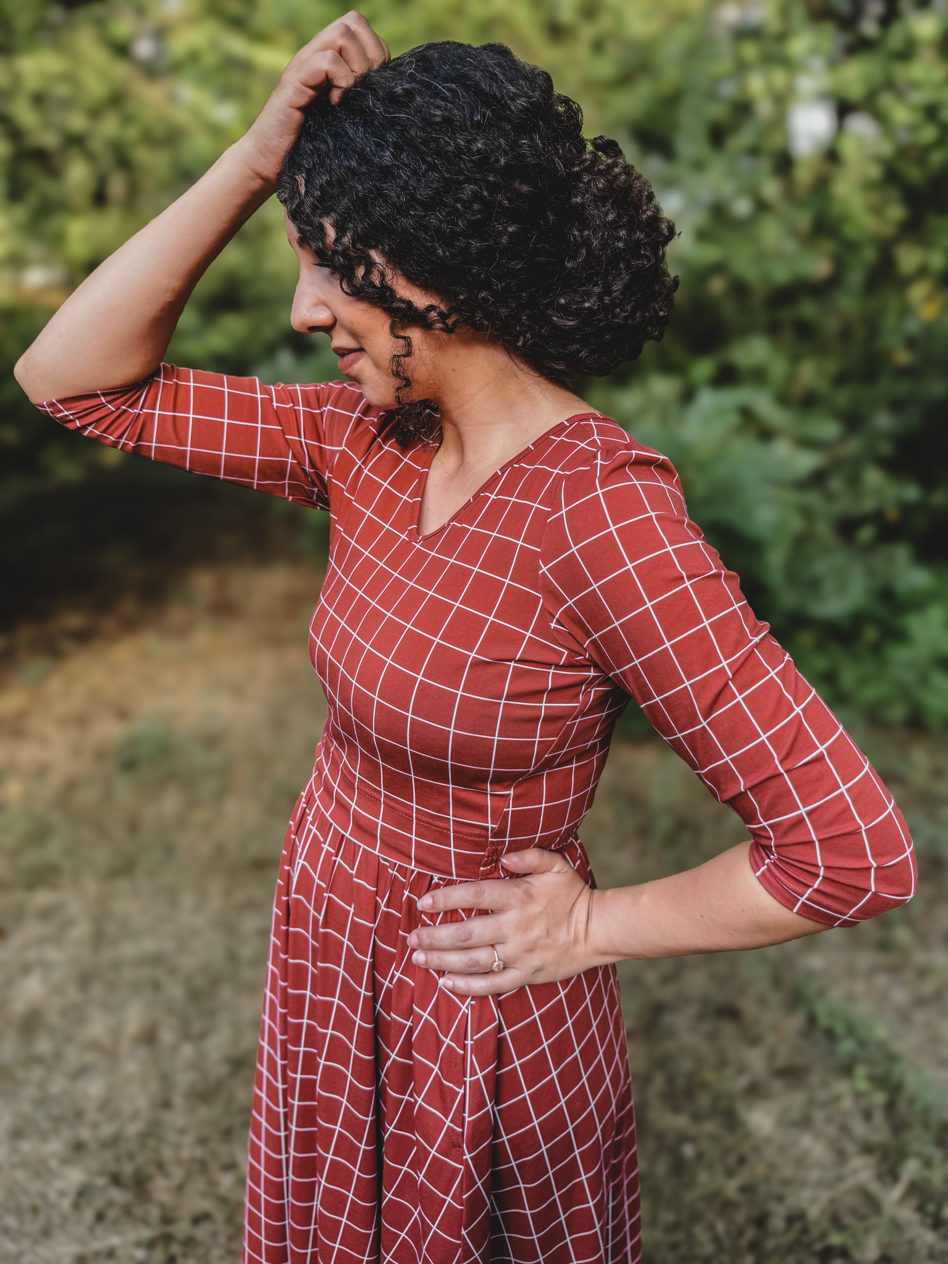 Woman in modest nursing copper windowpane maxi dress