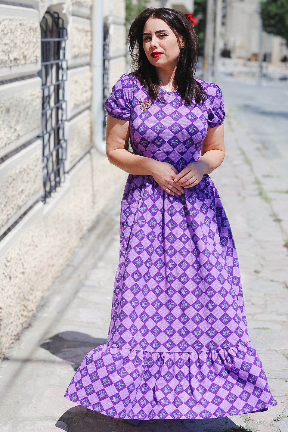 Woman in a purple checkered modest nursing dress.