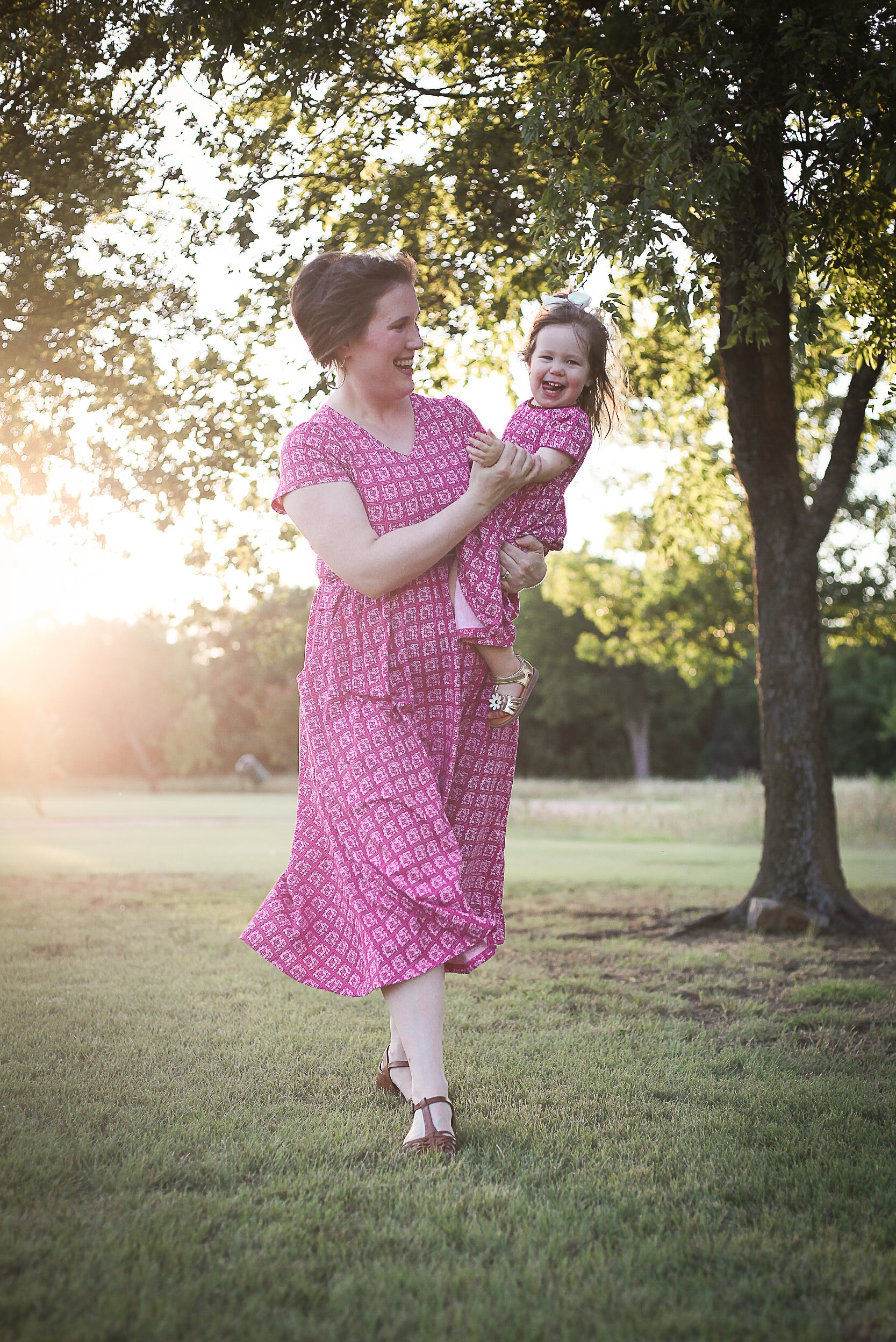 Young girl in a modest pink dress with her mother wearing a modest pink nursing dress