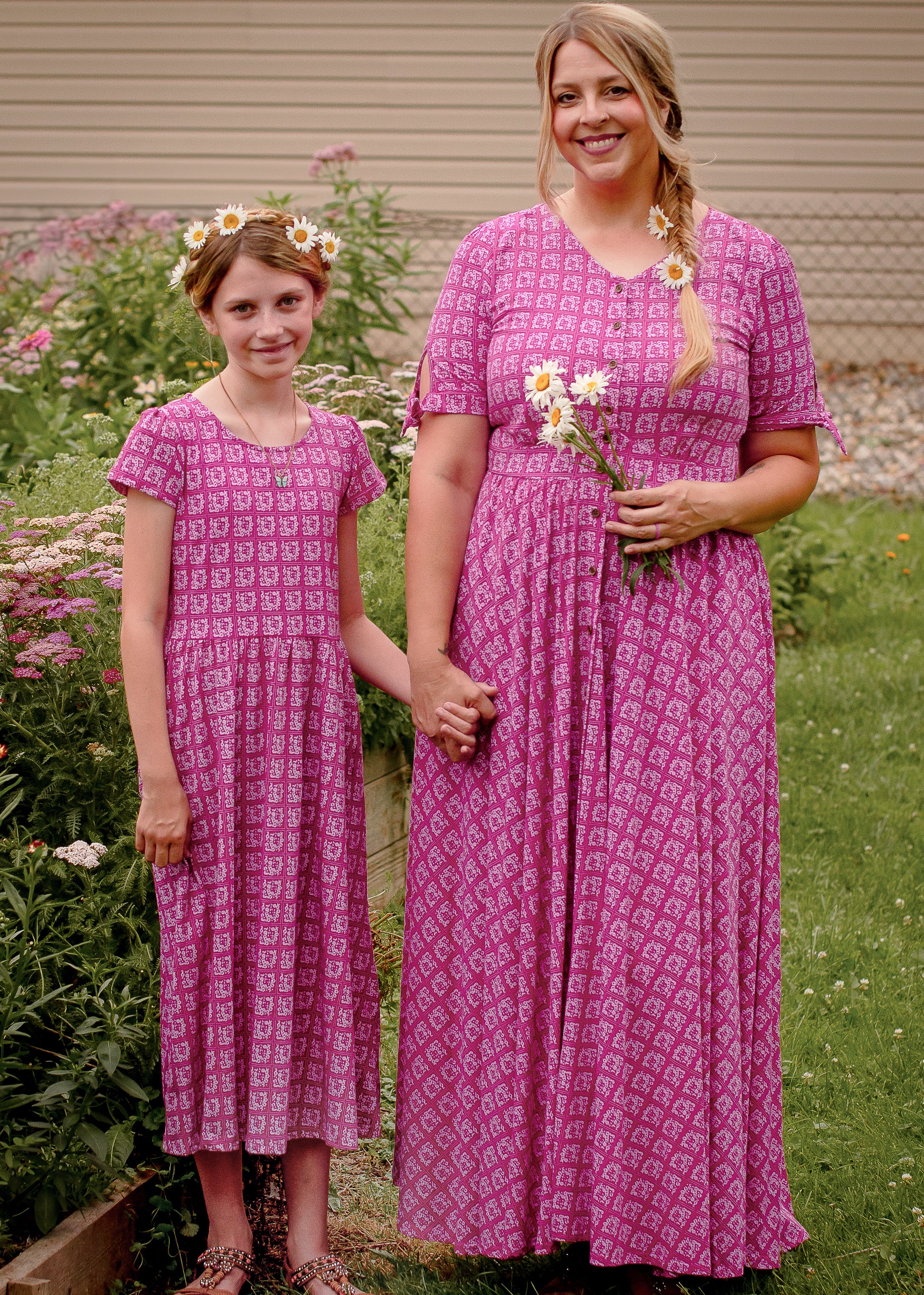 Young girl in a modest pink dress with her mother wearing a modest pink nursing dress