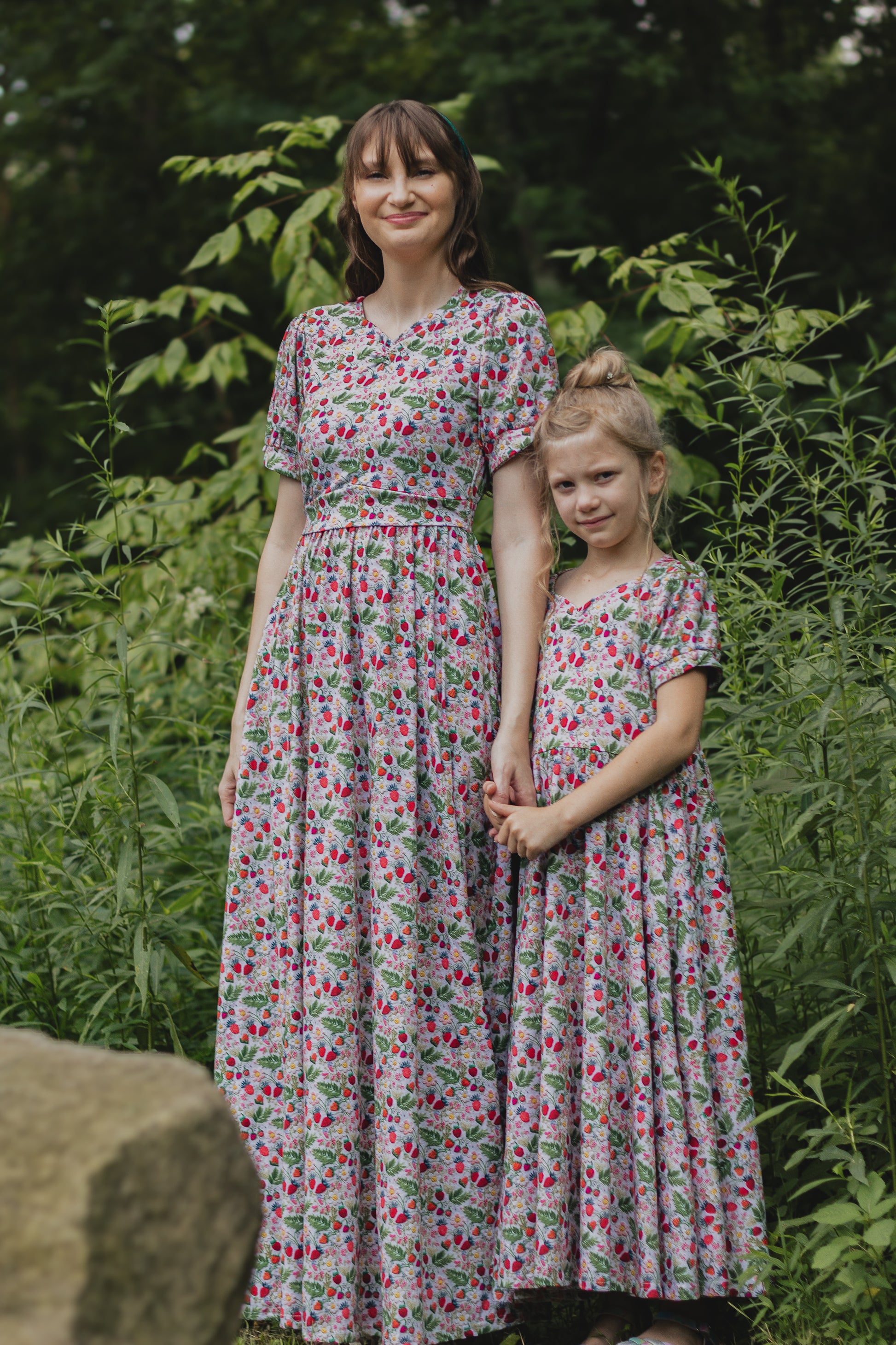 Woman in a floral modest nursing dress with her daughter wearing a matching dress.