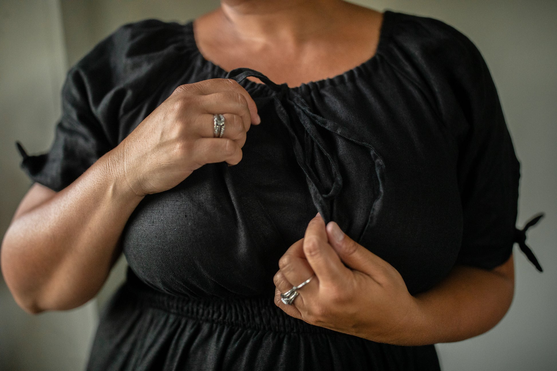 Person wearing a black modest nursing dress with a blurred background