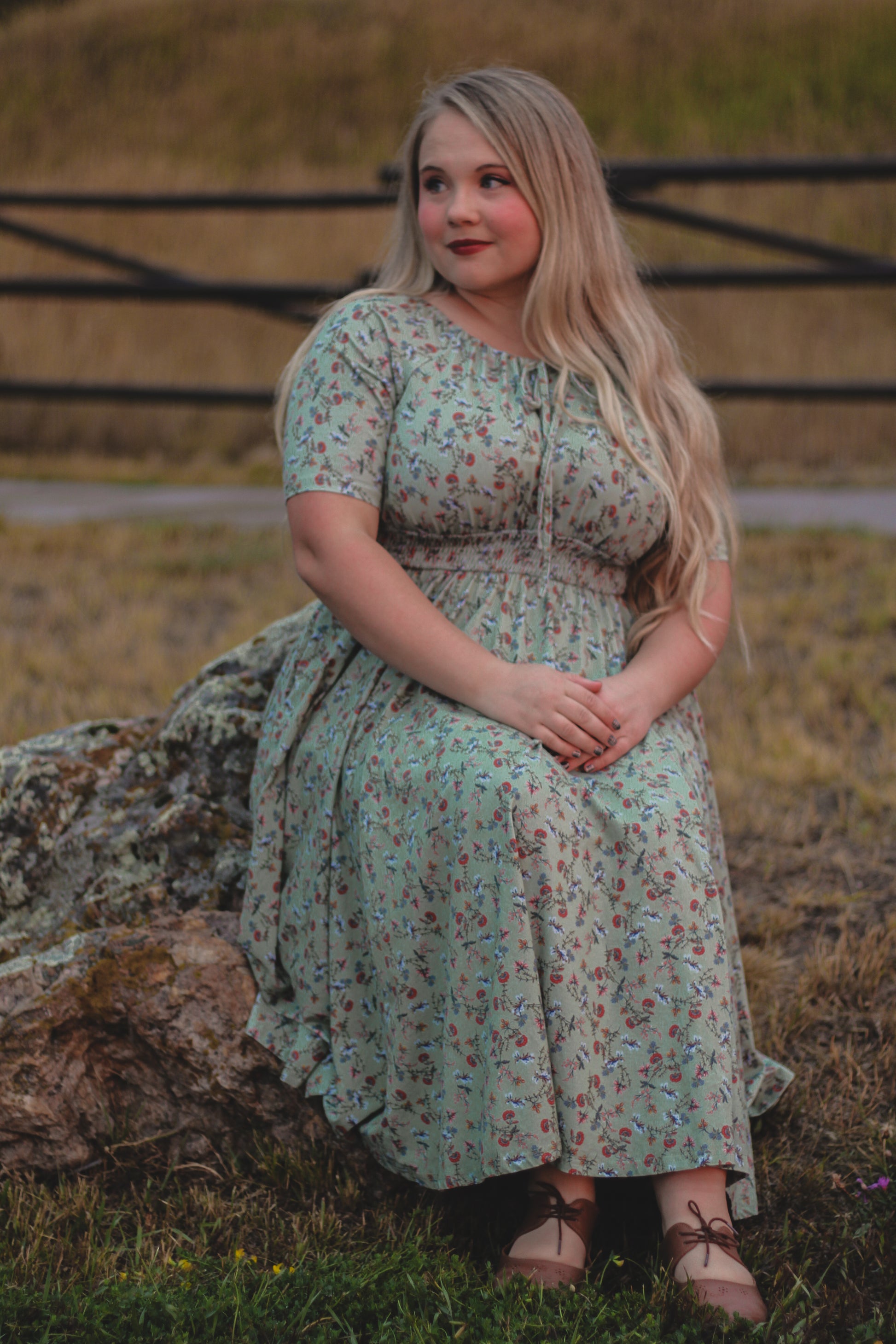Woman in modest nursing dress sitting outdoors