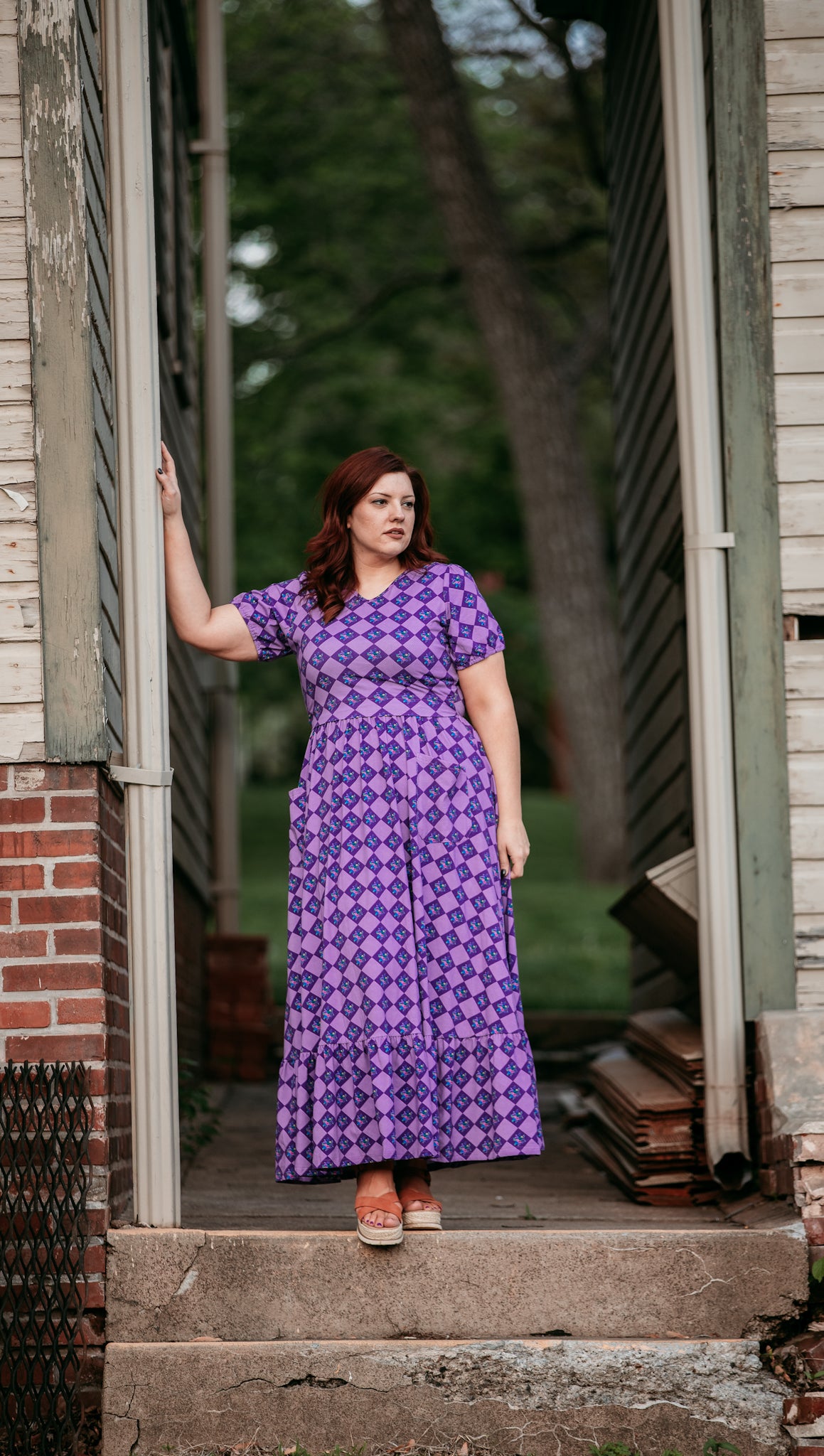 Woman in a purple checkered modest nursing dress.