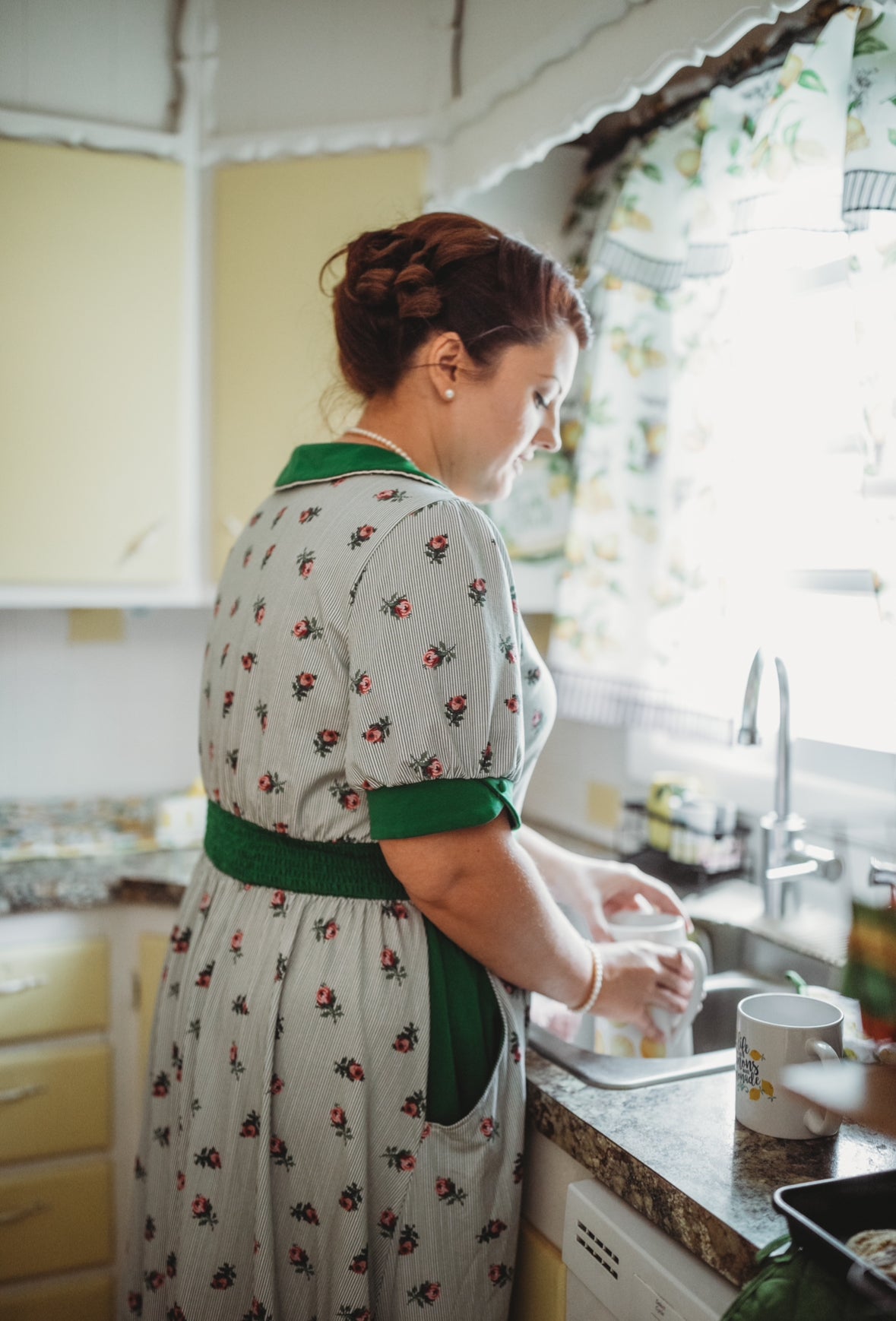 woman wearing a green and white striped modest nursing dress
