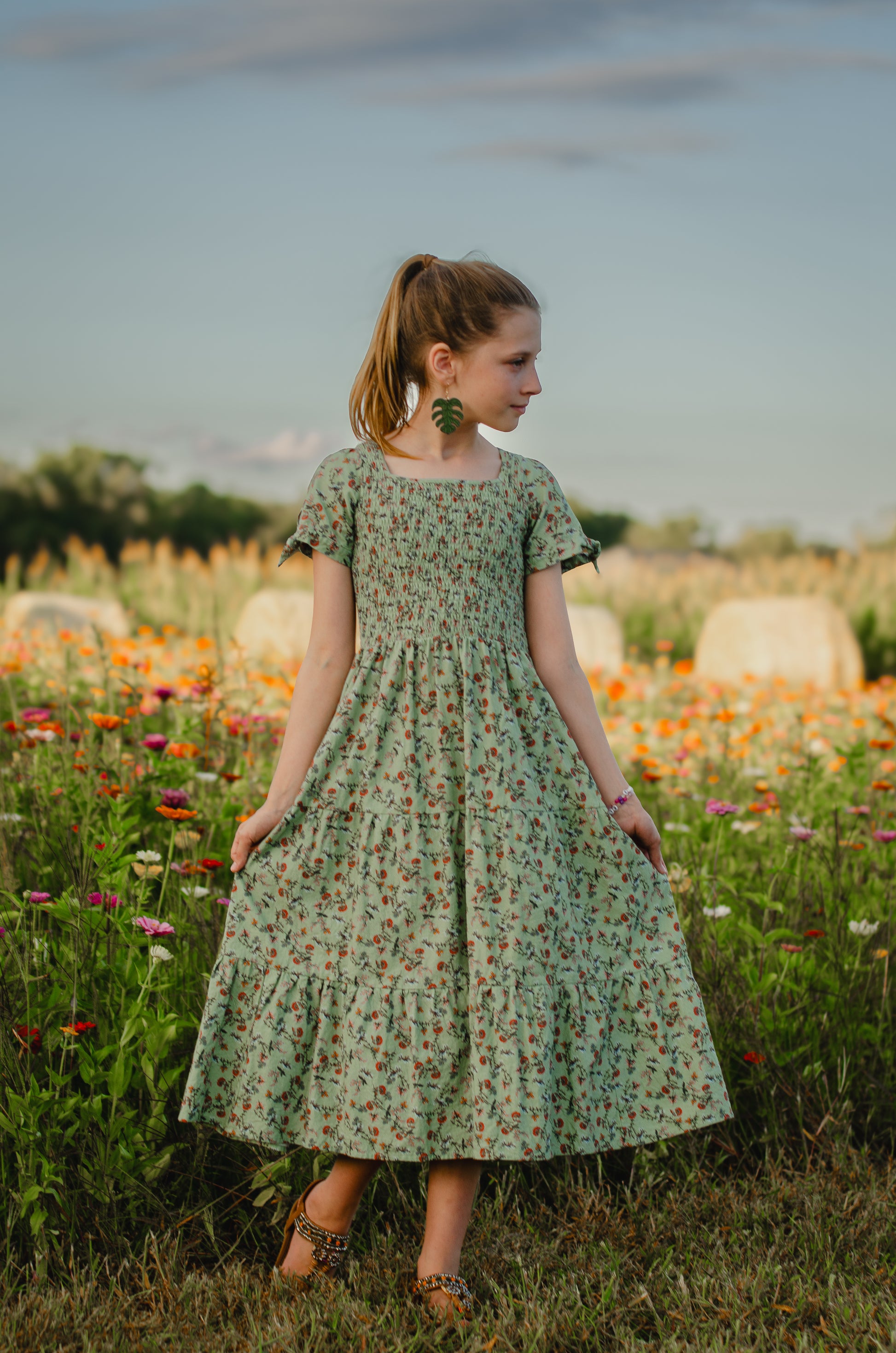 Woman in a floral dress standing in a field of flowers