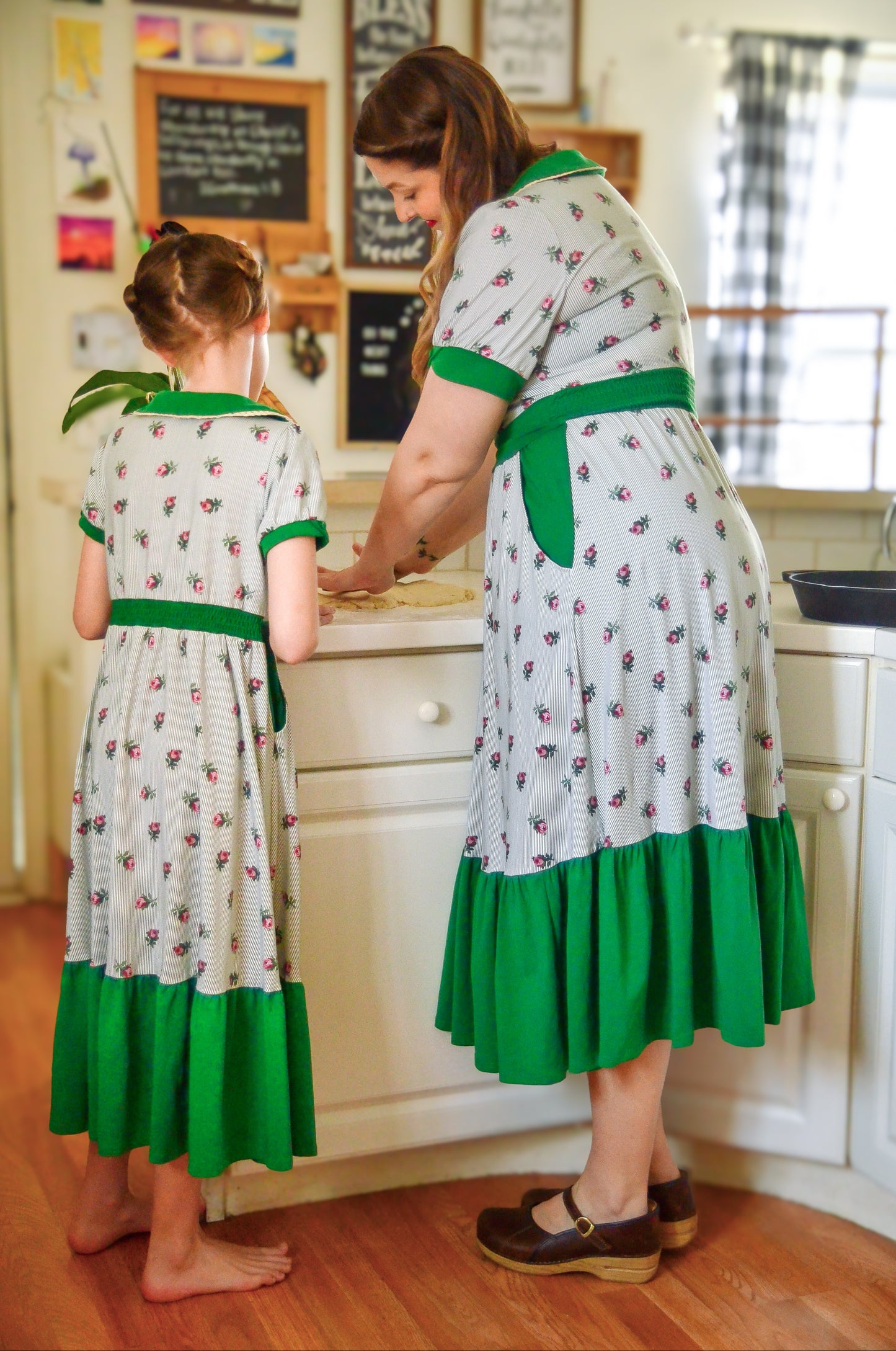 woman wearing a green and white striped modest nursing dress with her daughter wearing a matching dress