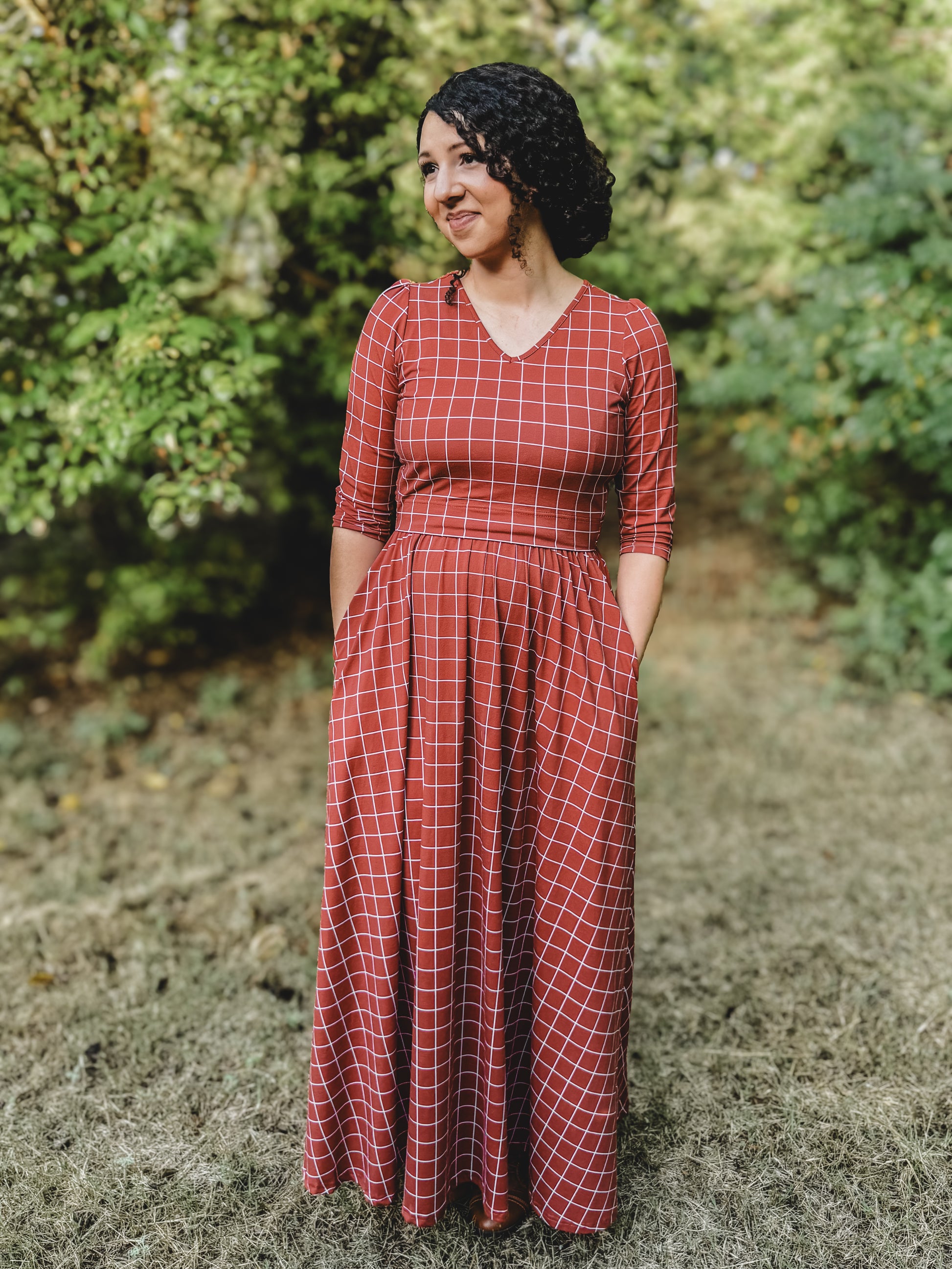 Woman in modest nursing copper windowpane maxi dress