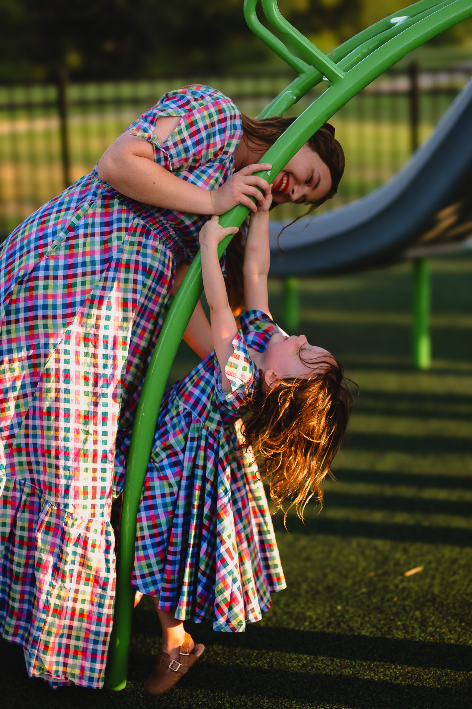 Young girl in a colorful checkered modest dress with her mother in a modest nursing dress