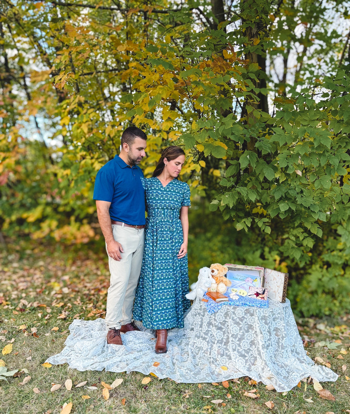 Couple with baby crib and teddy outdoors.