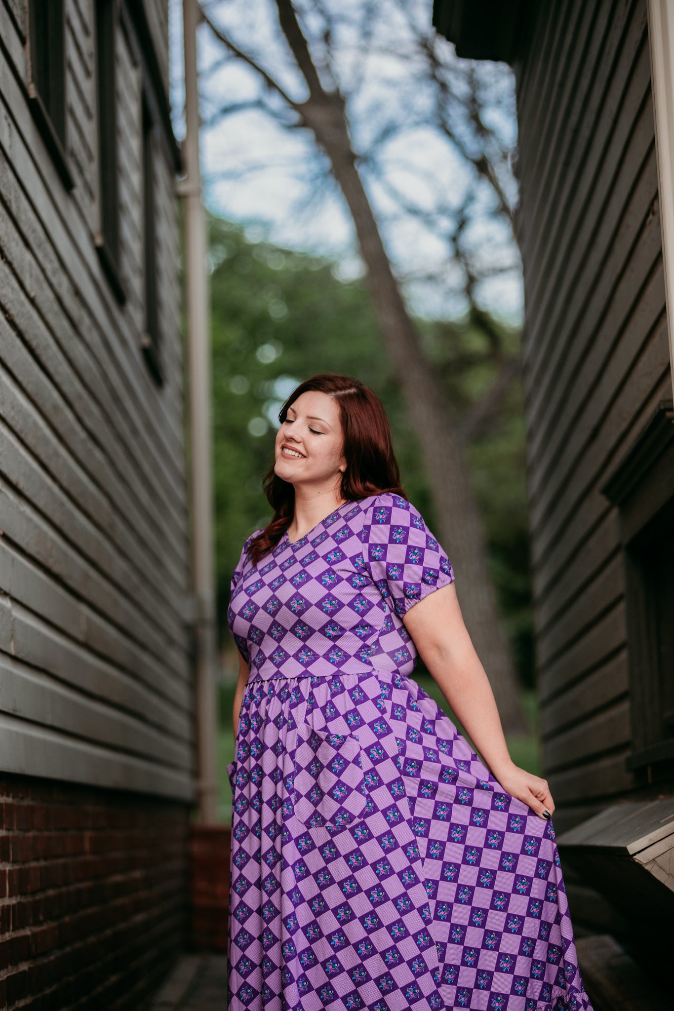 Woman in a purple checkered modest nursing dress.