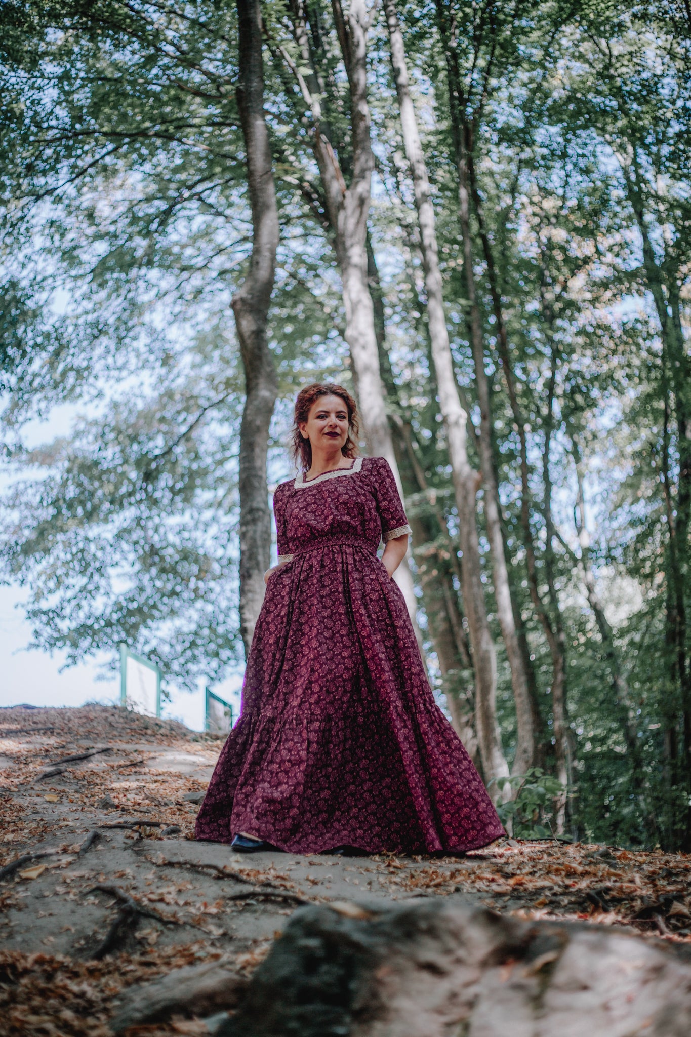 Woman in modest burgundy nursing dress outdoors