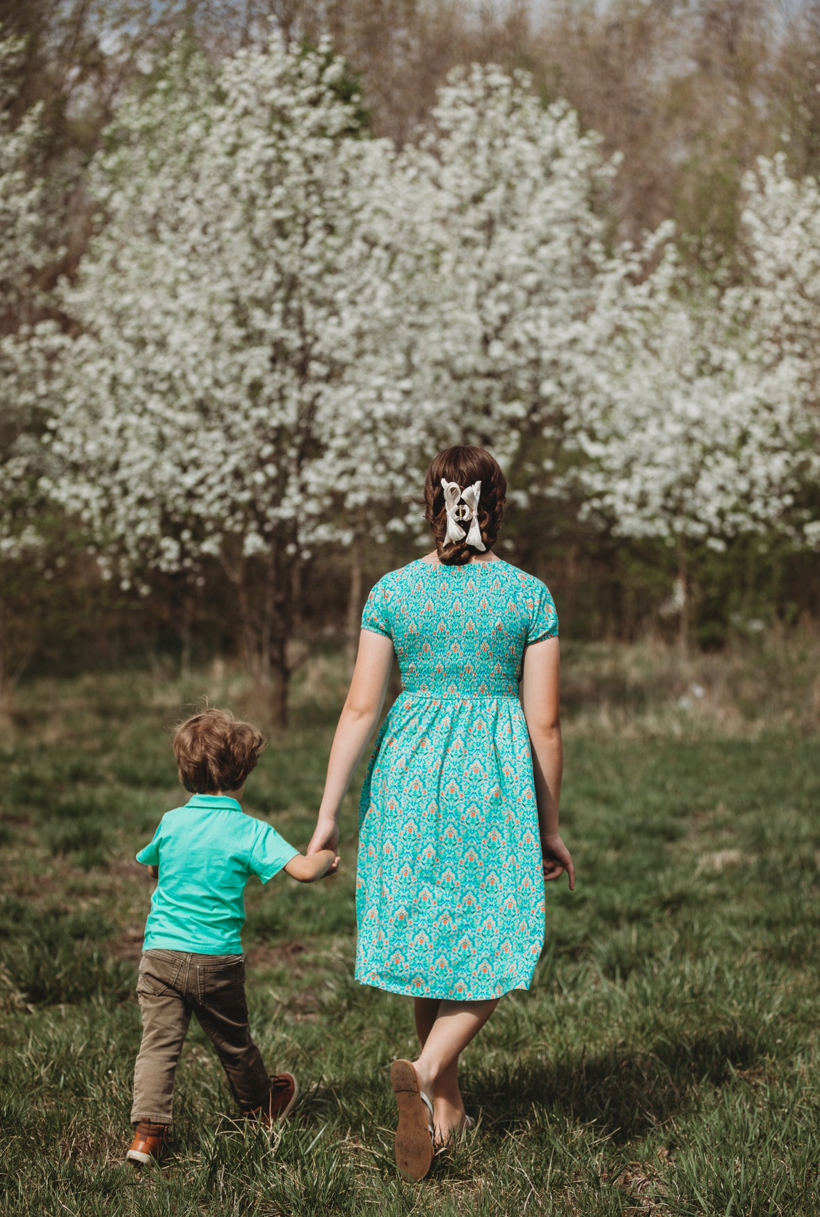 Young girl wearing a modest green dress with her brother wearing a green shirt