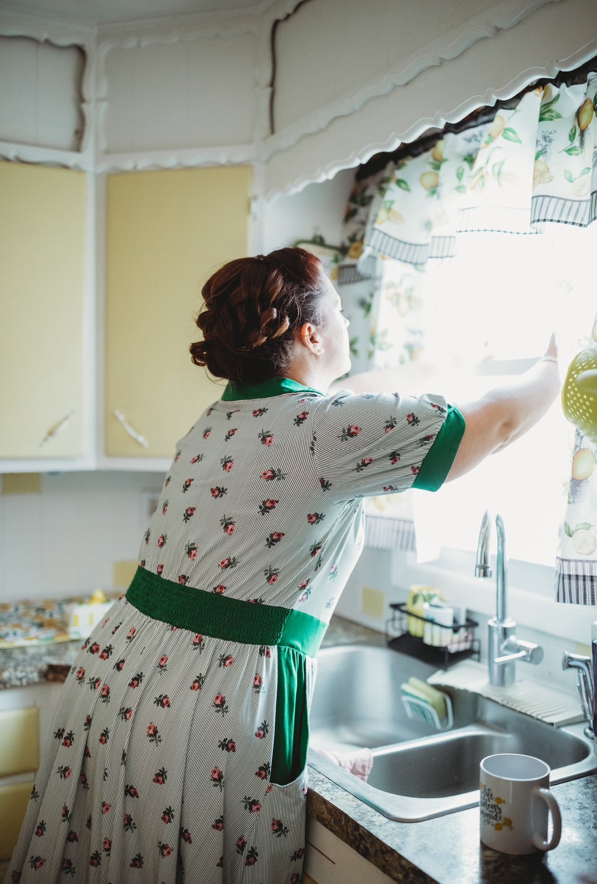woman wearing a green and white striped modest nursing dress