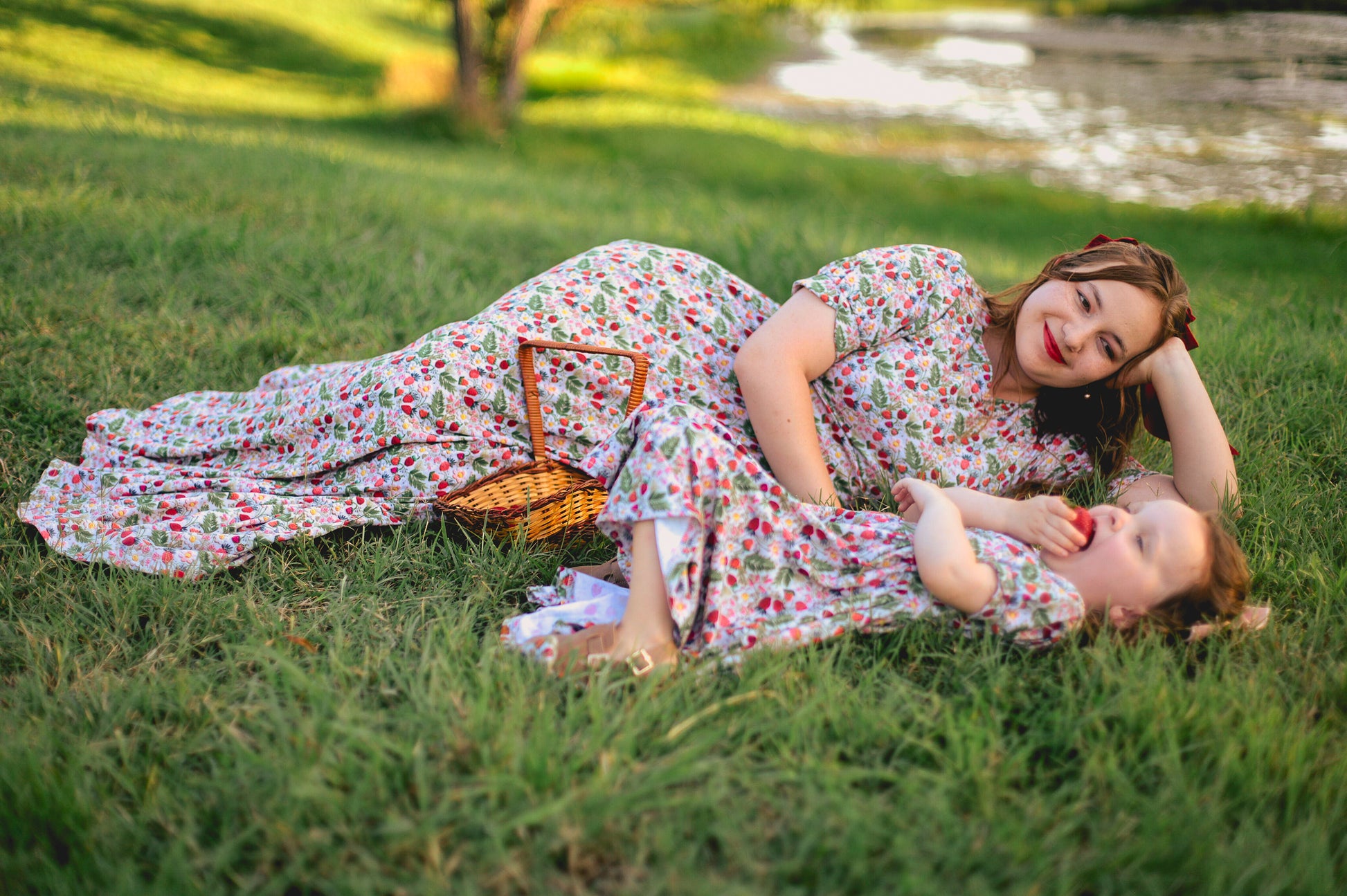 Woman in a floral modest nursing dress with her daughter wearing a matching dress.