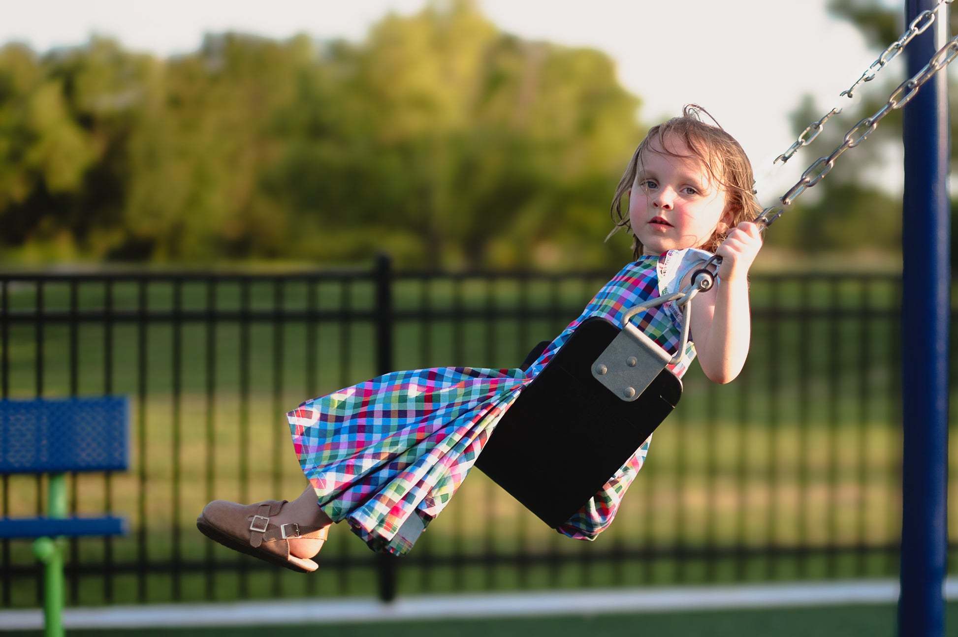 Young girl in a colorful checkered modest dress