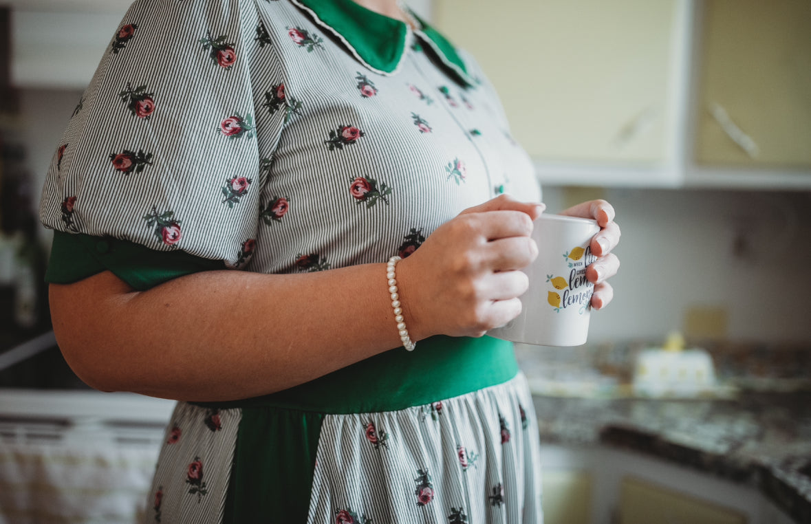 woman wearing a green and white striped modest nursing dress