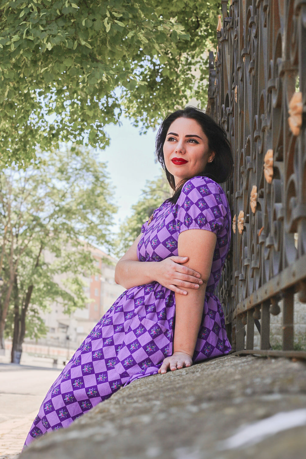 Woman in a purple checkered modest nursing dress.