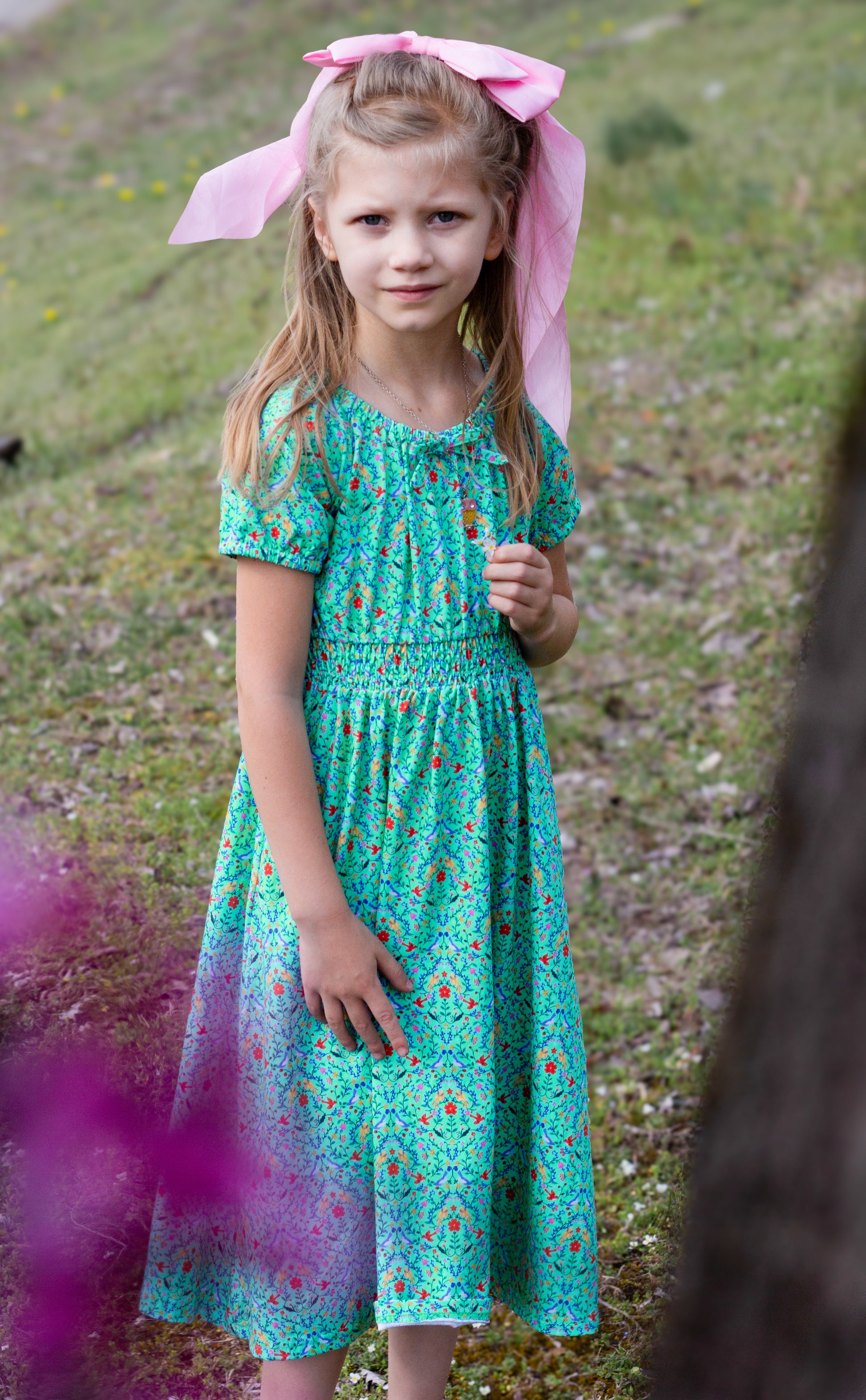 Young girl wearing a modest green dress with her mother in a modest green nursing dress