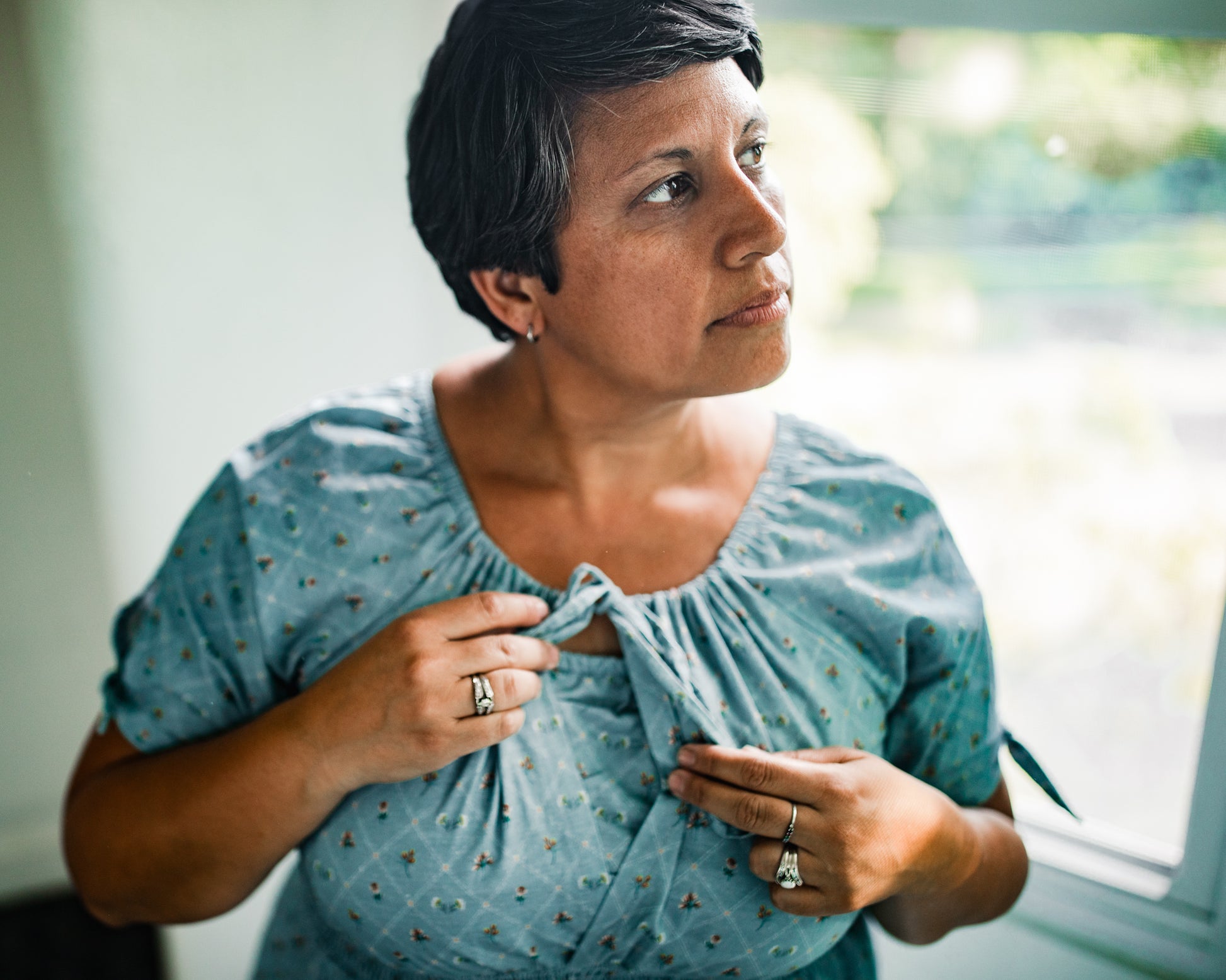 Woman wearing a modest nursing dress in a bright room