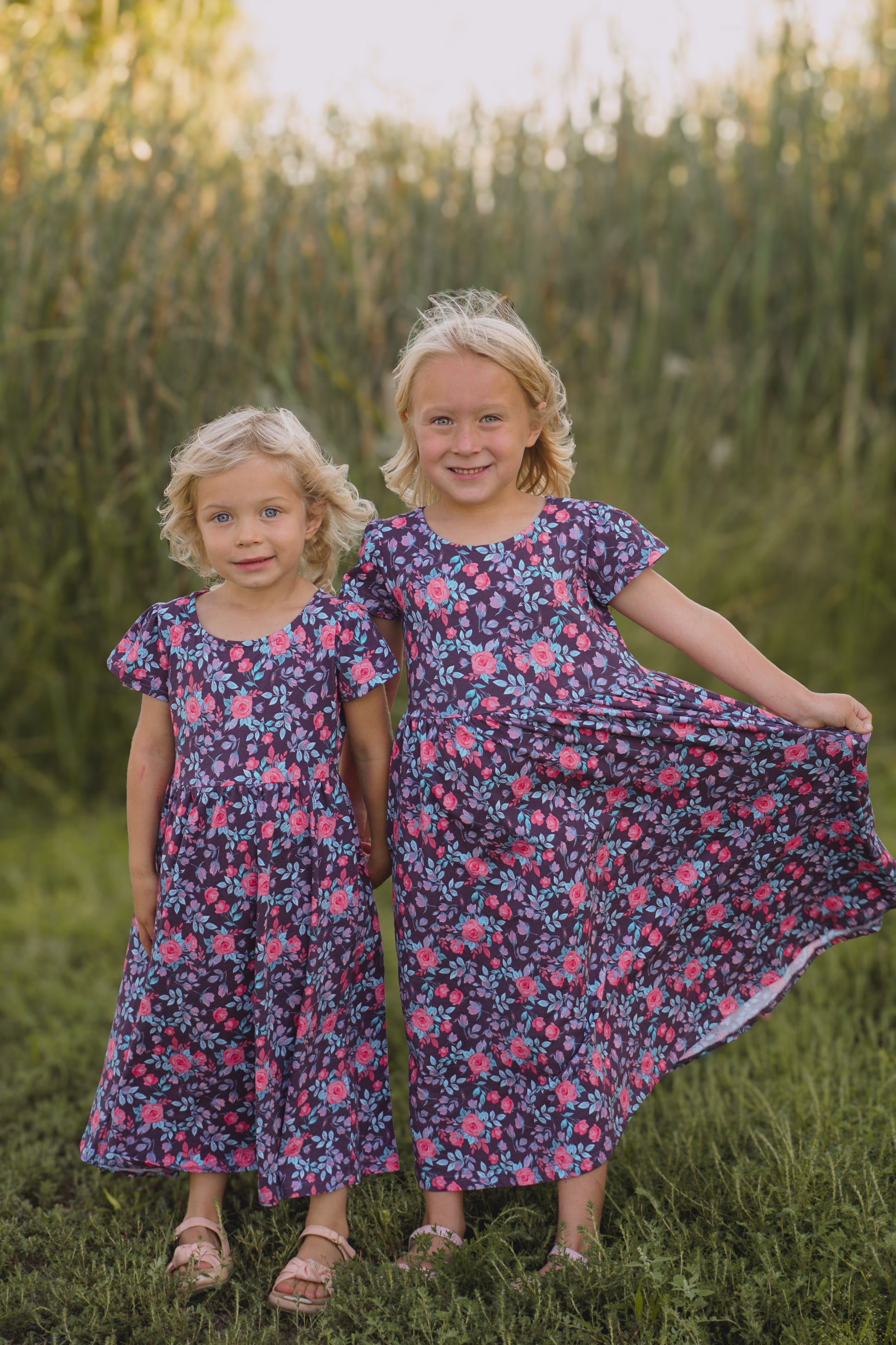 Two girls in floral dresses in field