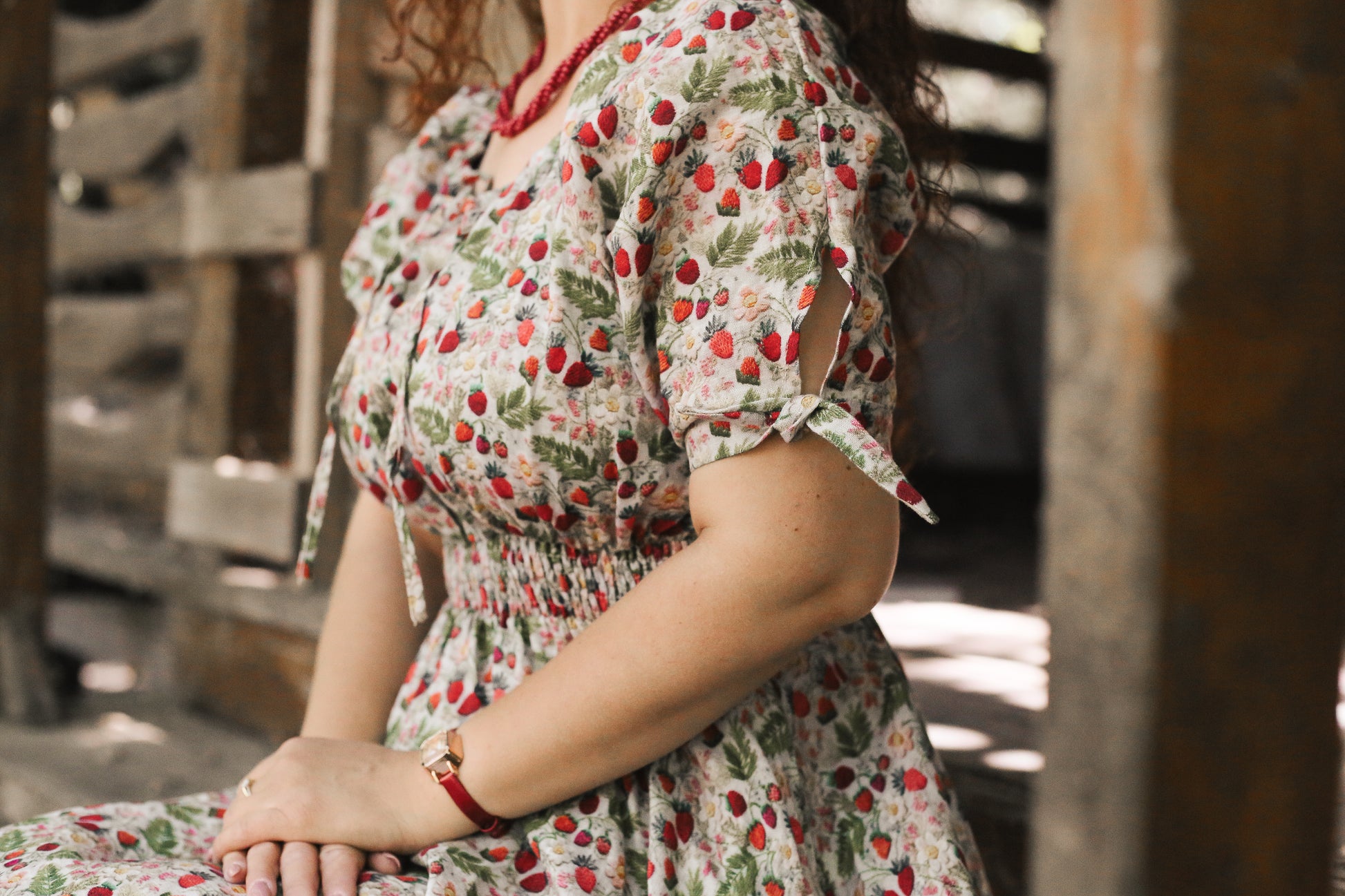 Person wearing a floral modest nursing dress with red berries in an outdoor setting