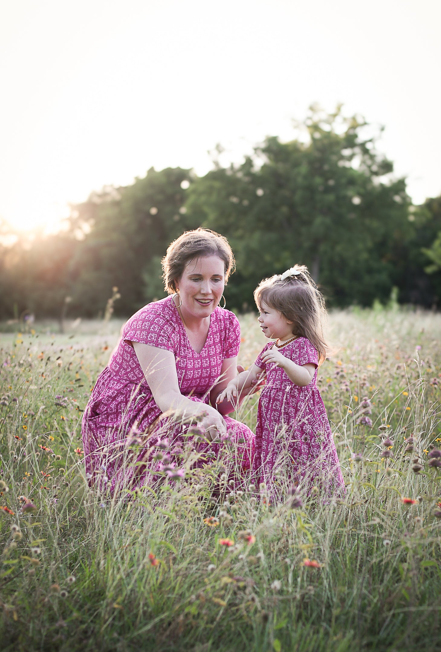 Young girl in a modest pink dress with her mother wearing a modest pink nursing dress