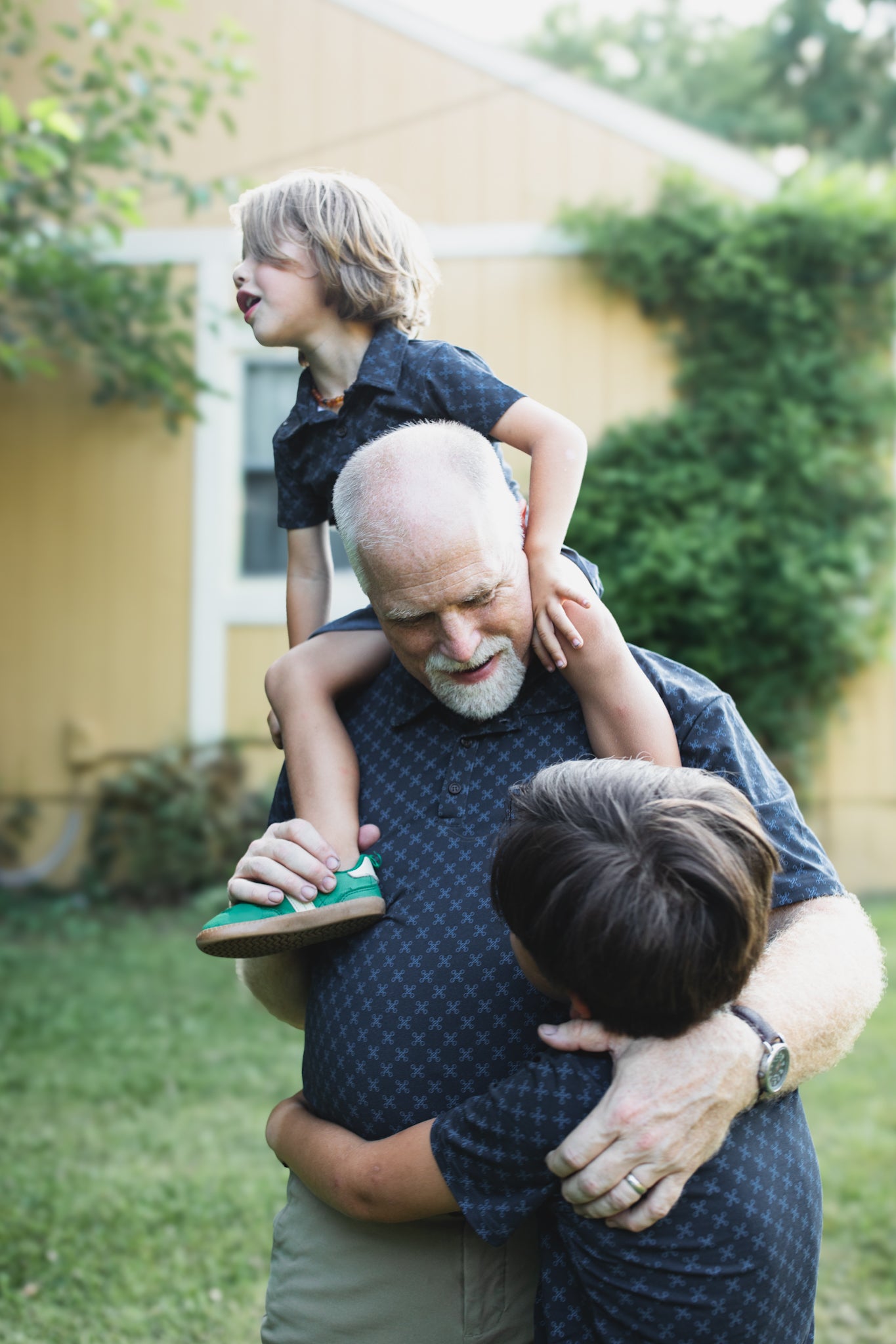 Young boys wearing dark blue polo shirts with their father in a matching shirt