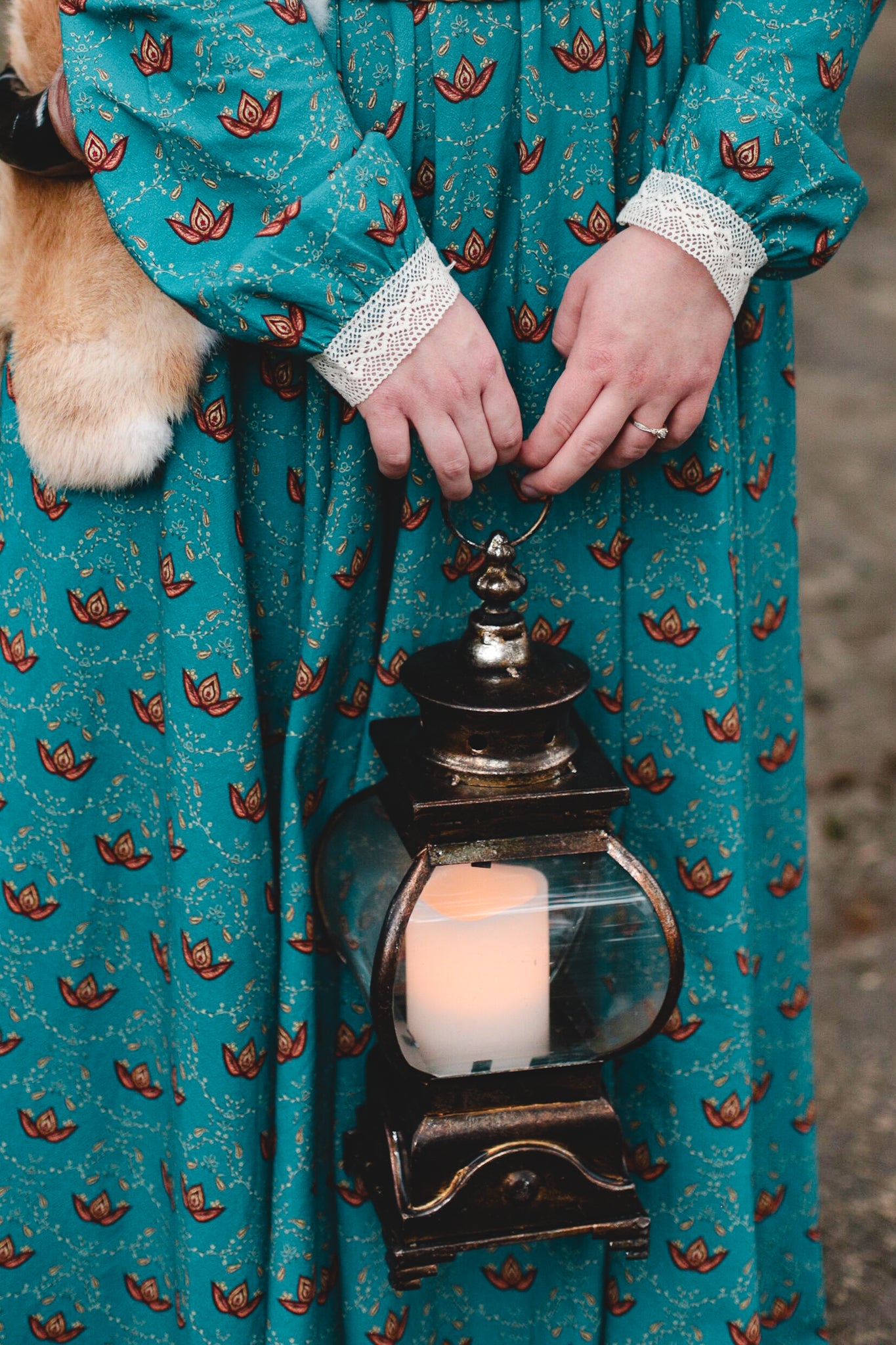 Woman in modest nursing teal dress holding lantern