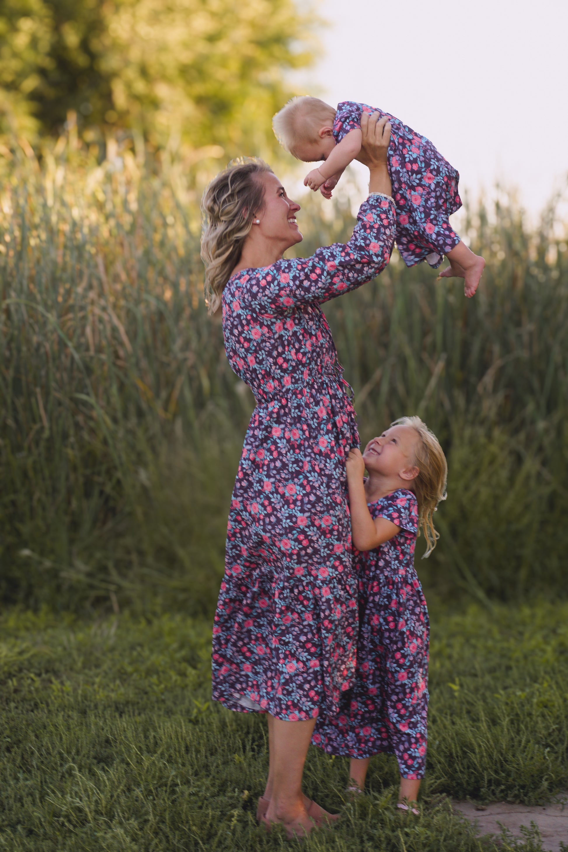 Woman in modest nursing floral dress with child outdoors