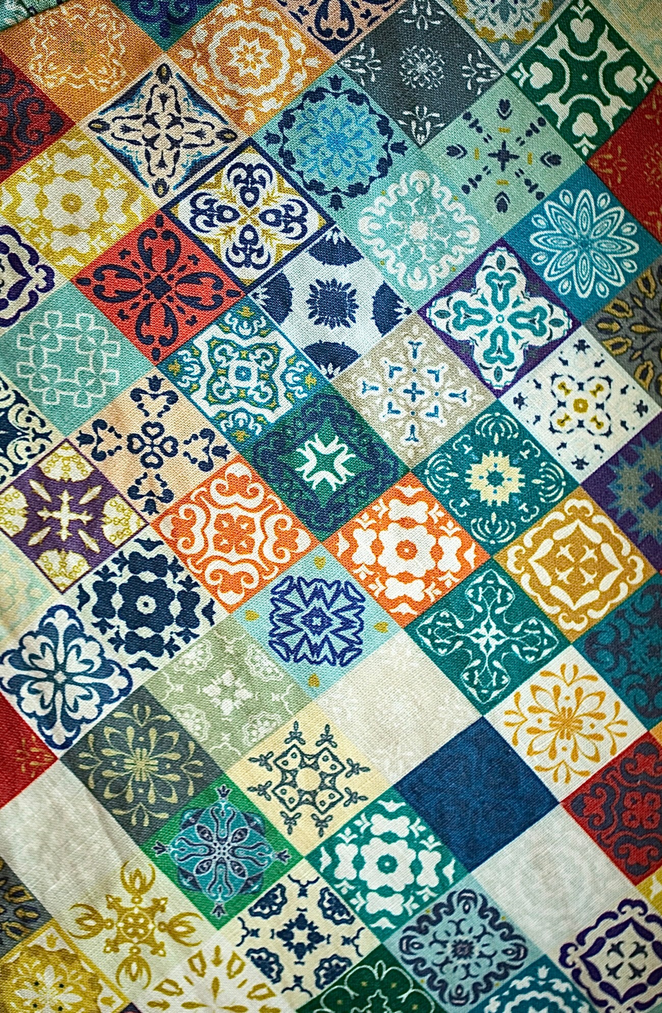 Multicolored patchwork patterned fabric with various geometric shapes and colors.