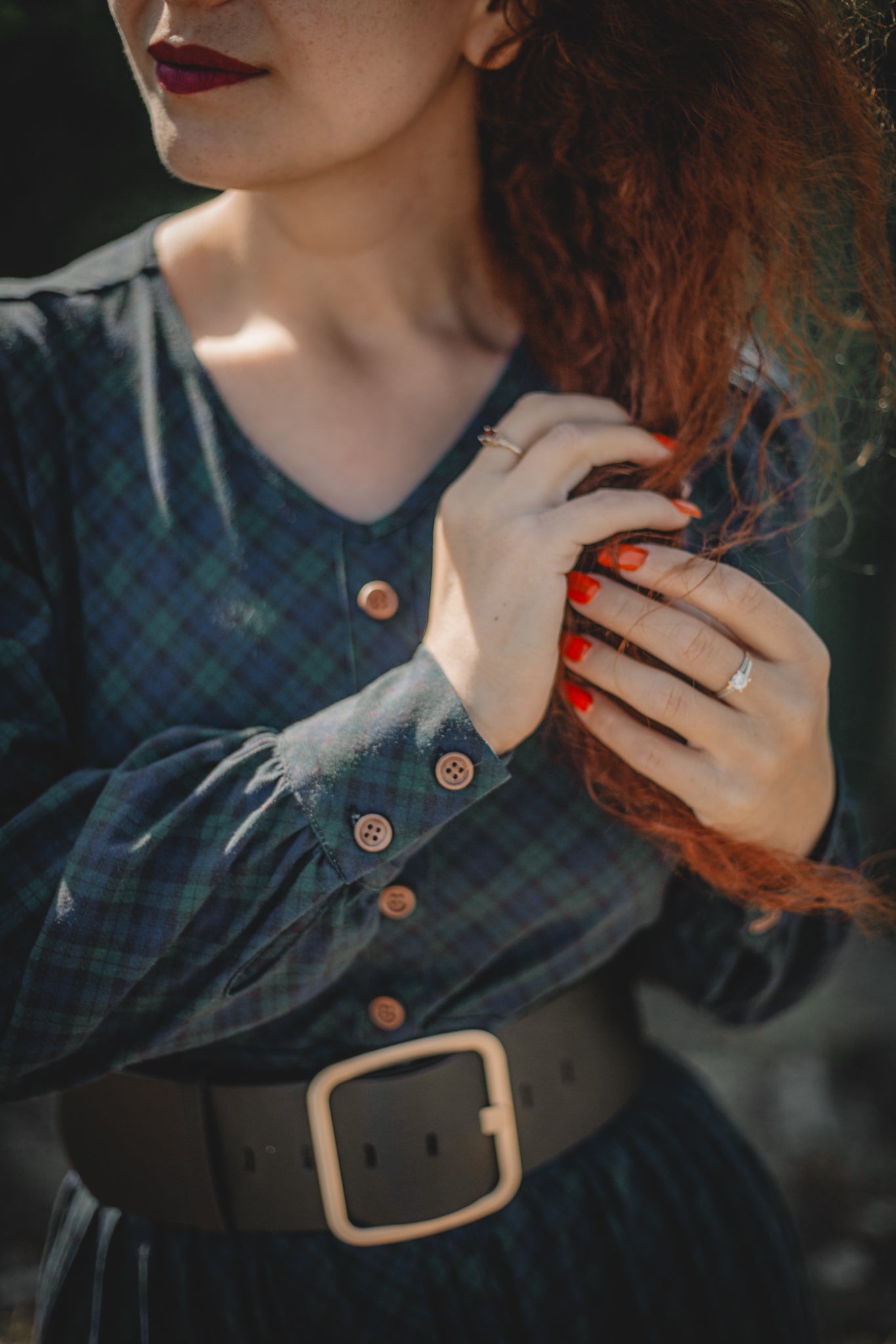 Woman in modest nursing plaid dress touching hair
